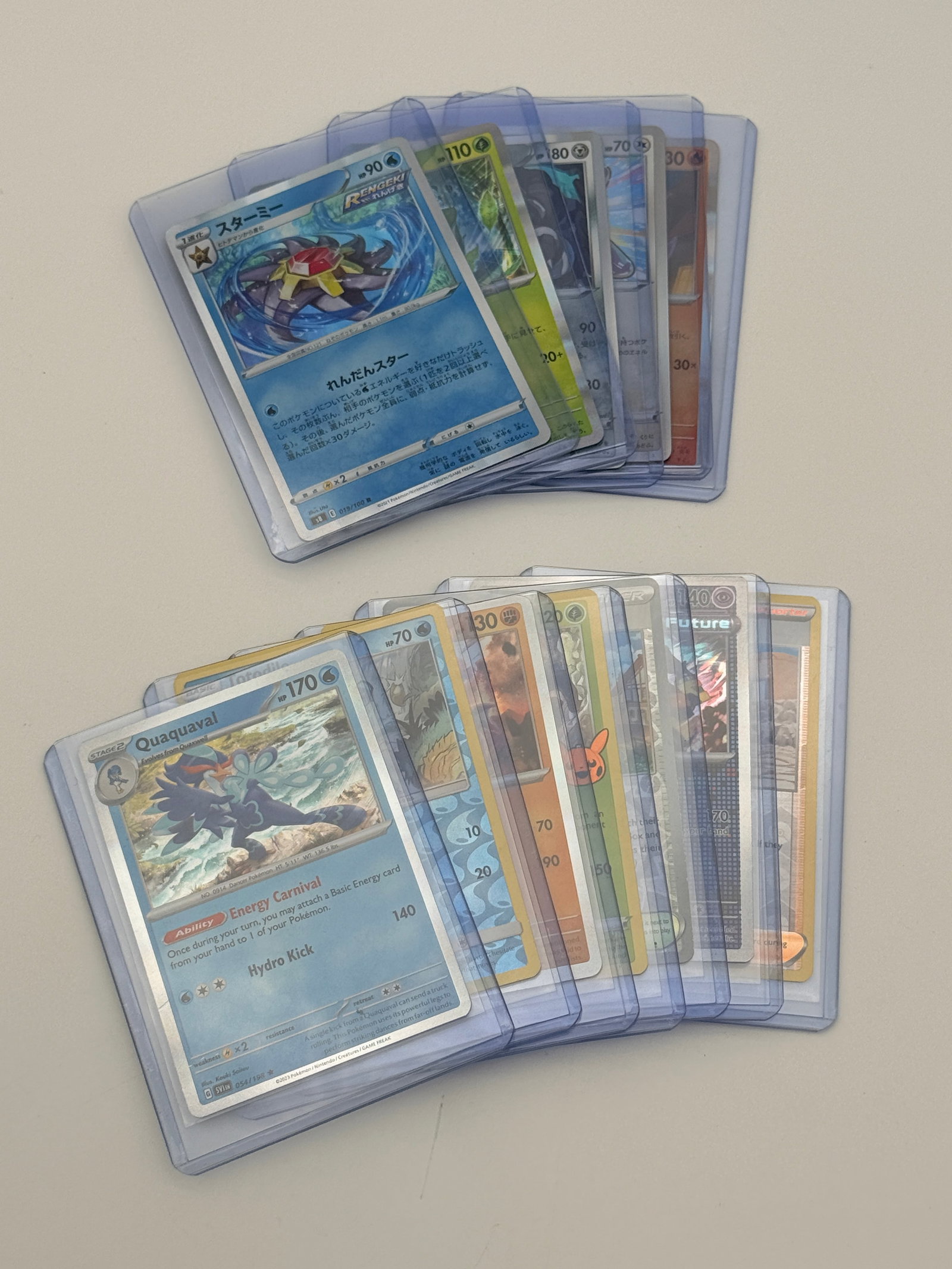 Pokémon Holographic Trading Card Lot: Mixed English and Japanese Pokémon trading card lot in protective sleeves.