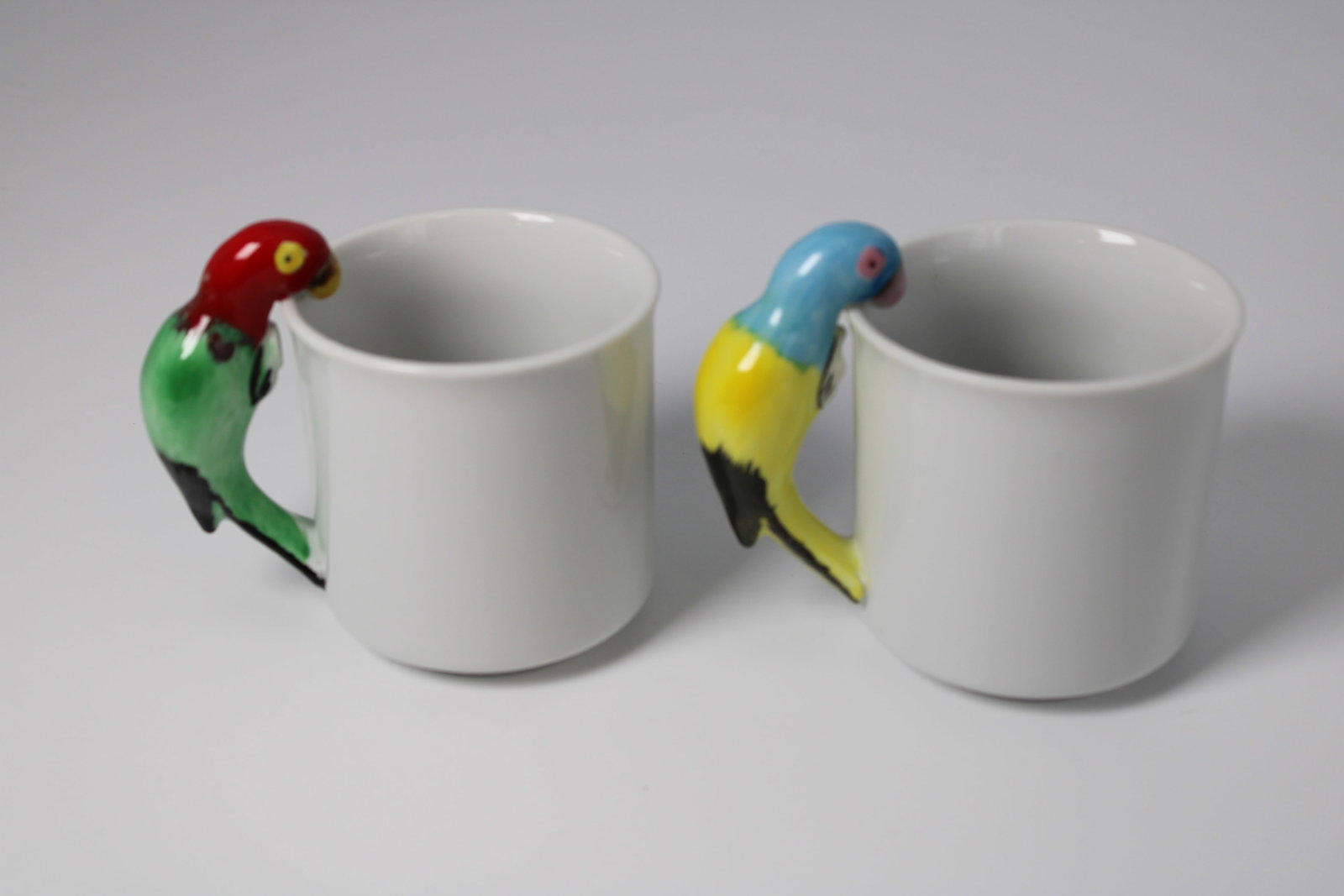Set of 2 Colorful Parrot Handle Ceramic Mugs: Each mug measures 4.5" wide x 3.4" tall, including the bird handle.