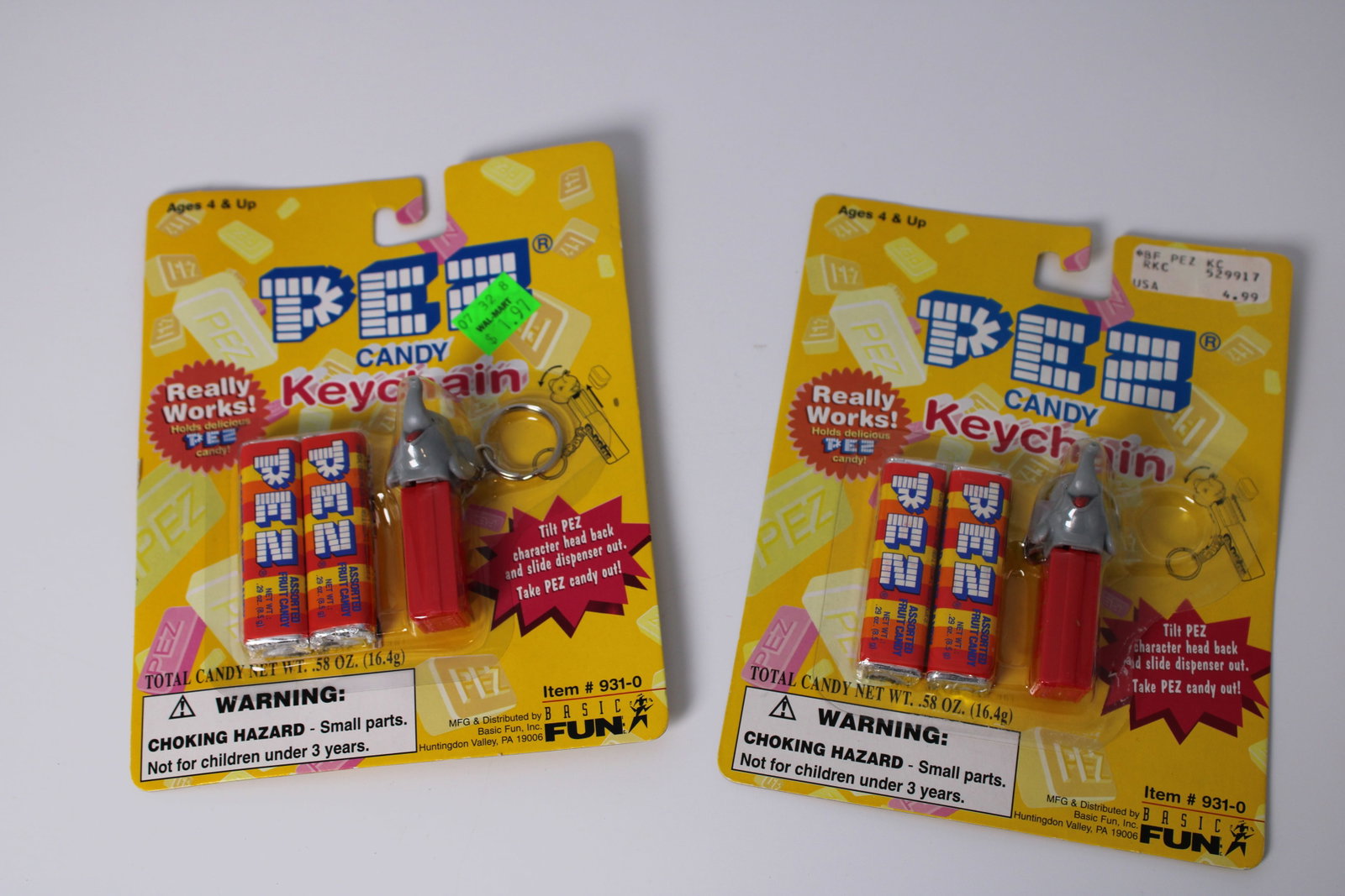 1998 PEZ Elephant Candy Keychains Pair: Two Basic Fun elephant PEZ keychain dispensers, item 931-0, with original candy. One blister pack is open, but the item remains unremoved; packaging has wear and price stickers. Candy is not for consu