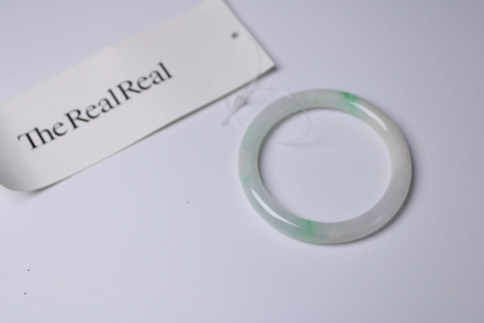 Pale Green Jade Bangle Bracelet: Polished pale green jade bangle with subtle green accents and a 1.9-inch inside diameter. Authenticated and tagged by The RealReal