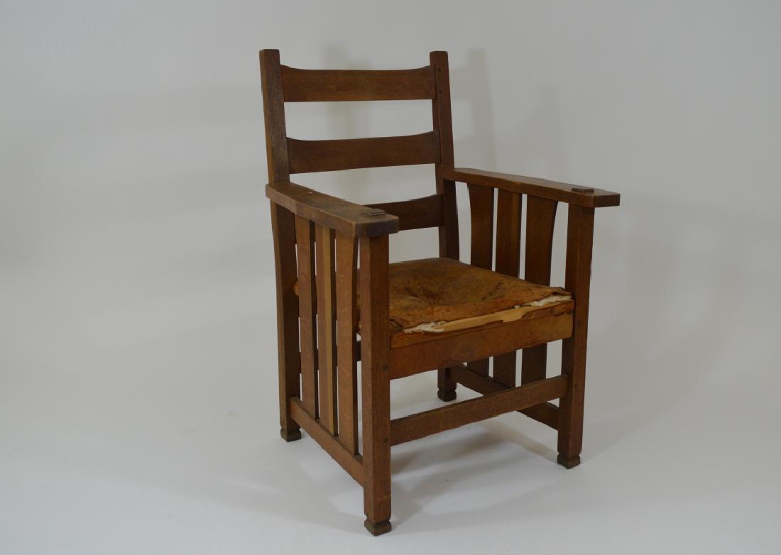 Stickley Arts & Crafts Arm Chair: Dry original finish, warn original leather seat, unsigned, mortised through arms, pegged construction. Years ago someone carved mackmurdo feet. Number stenciled on bottom of seat 7557A.