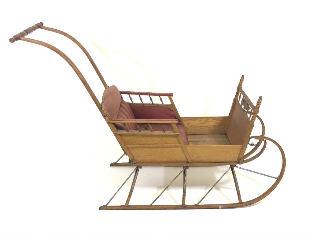Paris Manufacturing Company Push Sleigh No. 5: made of oak, natural finish, circa 1890's, original red felt upholstery, bells on front, total length approximately 4 feet.