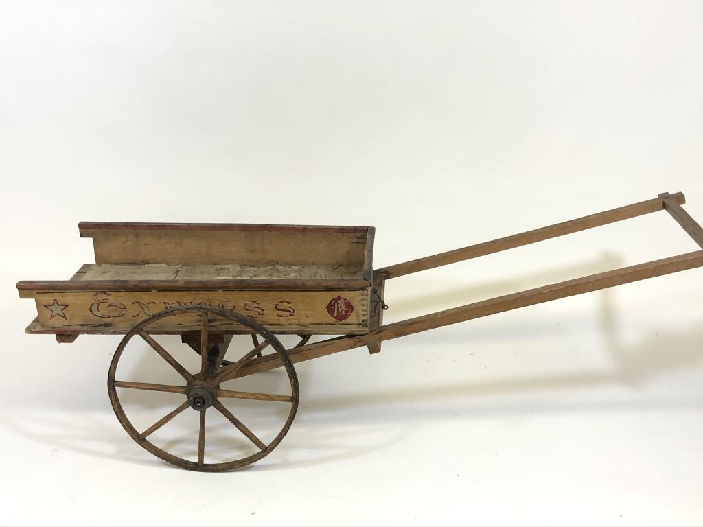 Paris Manufacturing Company "Express" Pull Cart: two wheeled dump cart, box measures 14 inches x 30 inches, 17 inches diameter wooden spoke wheels, missing tailgate.