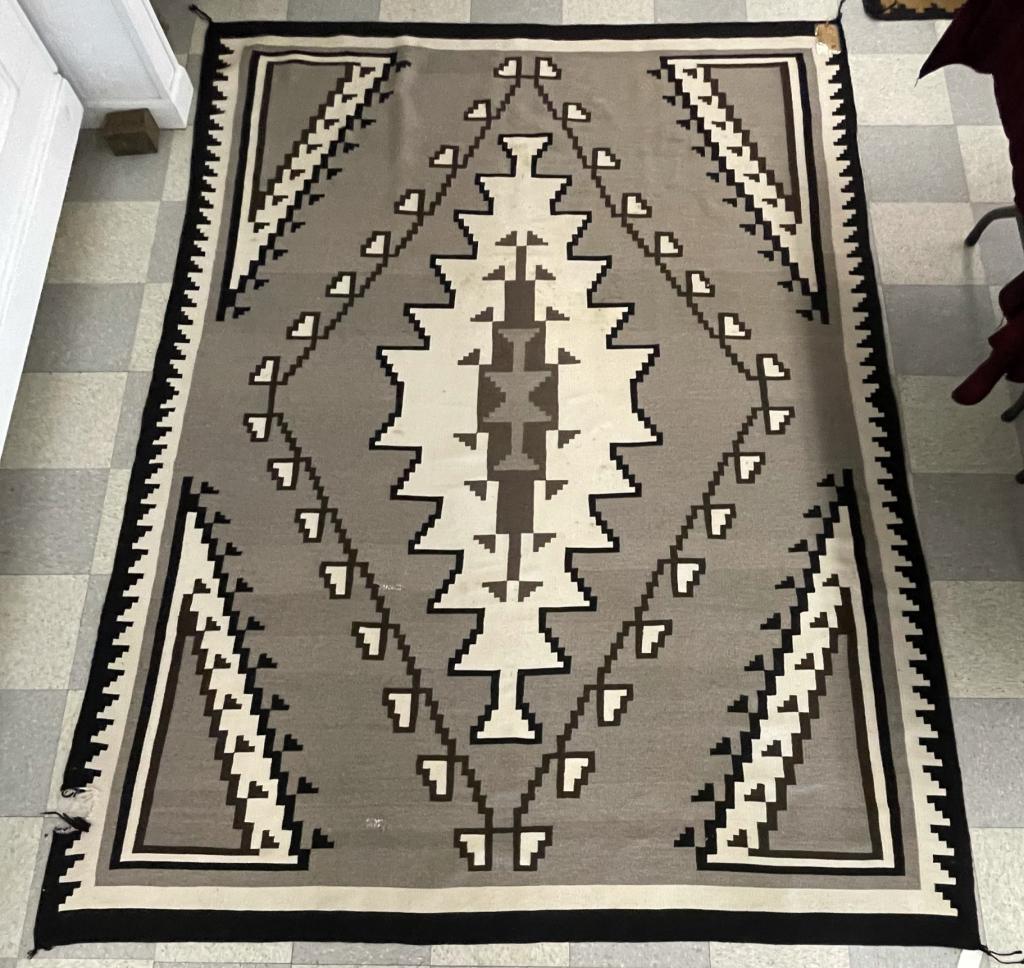 Large Navajo Room Size Rug: purchased at the Hubbell Trading Post, Ganado, AZ. Approximately 7' x 9'. From the Sid Bell Estate. Tag on the rug states this rug was purchased on an Elk hunt in 1968, rug cost 3 times as much as the