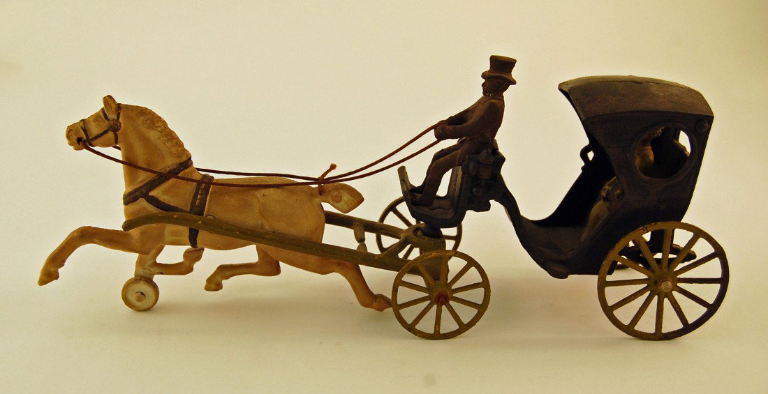 Cast iron toy horse and buggy with man and lady: Mid 20th century. 15 1/2 inches long