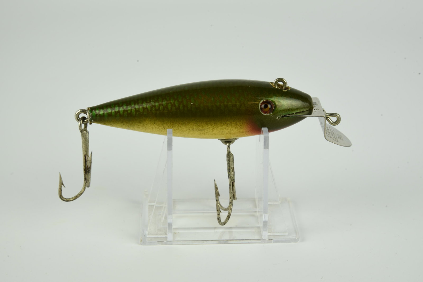 Creek Chub 109 Wiggler: Early lure with red in the eye sockets and finished in brilliant greenback, dated lip and good glass eyes, other than a barb cut from each hook about VG+ condition.