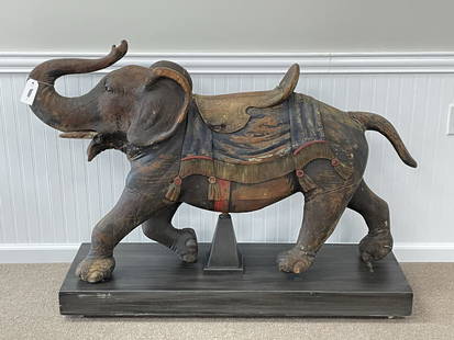 Rare Wooden Carved Carousel Elephant: Attributed to the work of Charles Looff. (1852-1918). In original paint with glass eyes, some old repairs, paint flaking and chips, displayed on a mobile wooden base. Circa 1900. Carved in the Coney