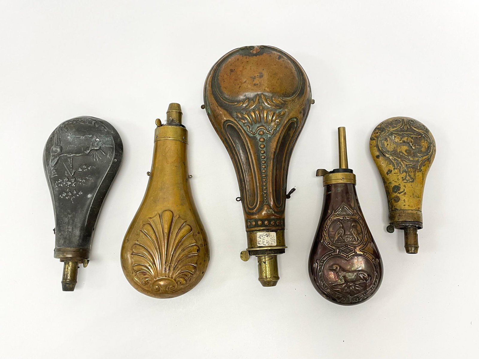5 Early Gun Powder Flasks: 4 made out of brass, largest is 9 1/2", smallest is 5 1/2". From the Estate of Carlton Stickney, County & Town Historian and Lifetime Collector.