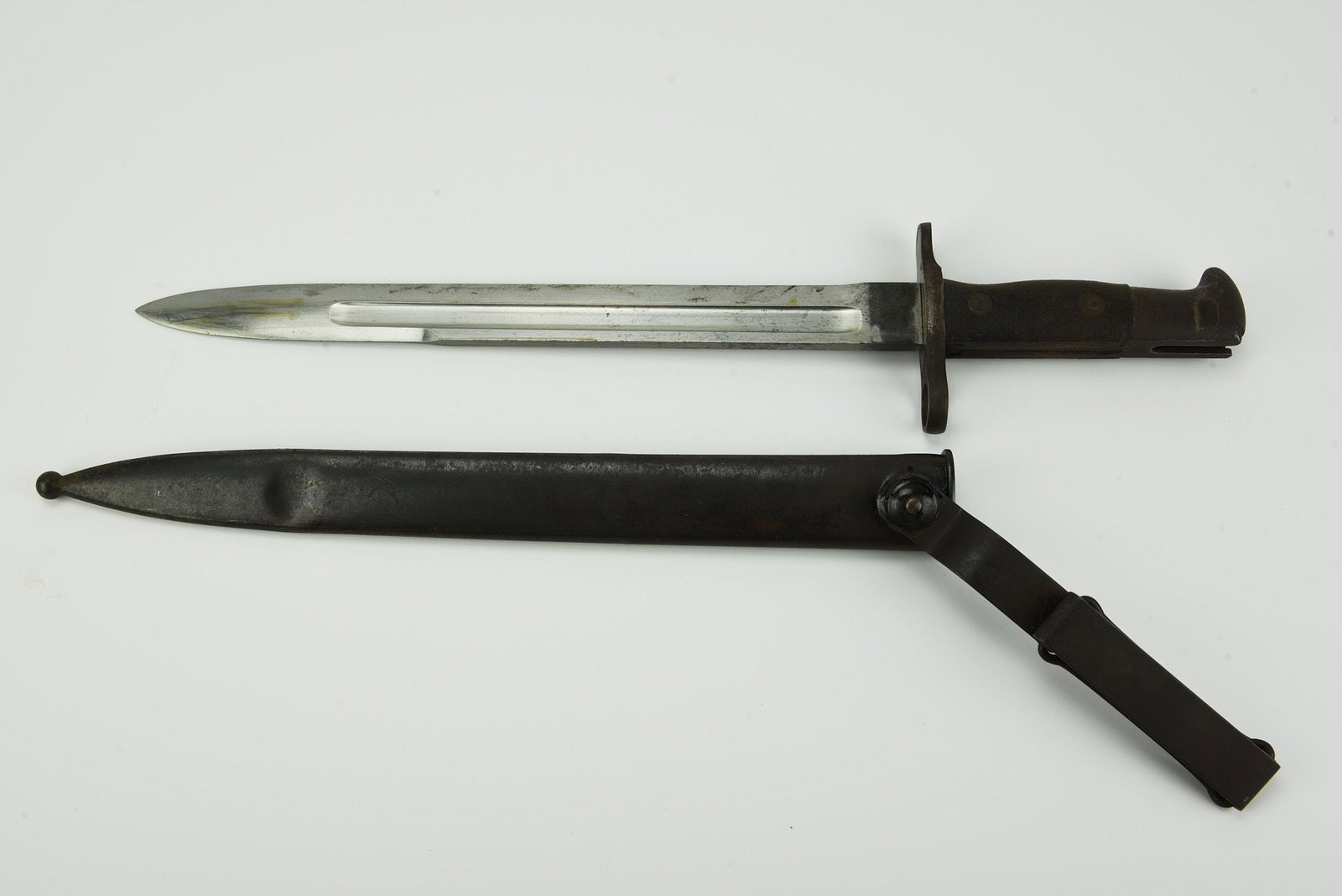 Antique Bayonet: Turn of the century, 11 3/4" blade, stamped "US" on one side "1900" on the other, original scabbard with a swivel belt hook, wood handle grips, the lock/release button functions. With expected wear an