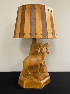 Big Horn Sheep Wooden Carved Table Lamp: signed C. Dube. 31" tall. Impressive size, Canadian carver, tip of one antler has been replaced and there is a small chip in the rim of the shade. Otherwise, in good condition.