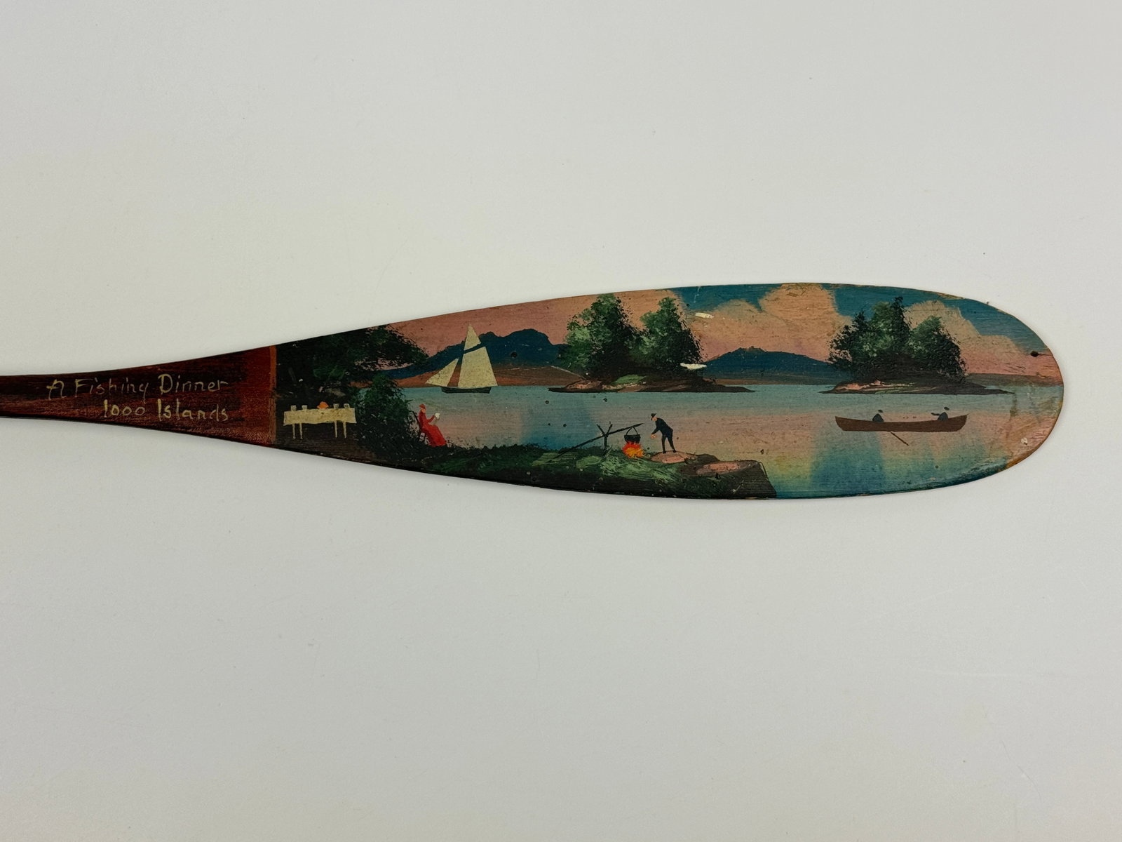Alpheus Keech "A Fishing Dinner" Paddle: 1000 Islands souvenir paddle measures 21 3/4" long. 2 small tack holes.