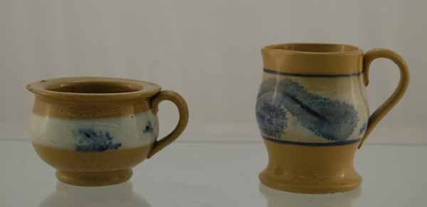 Two small pieces of Mochaware: 1 3/4" spittle cup and a 2 1/2" tall pitcher. Both yelloware with blue mocha seaweed pattern. Pitcher excellent condition, Spittle cup has a small chip in rim.