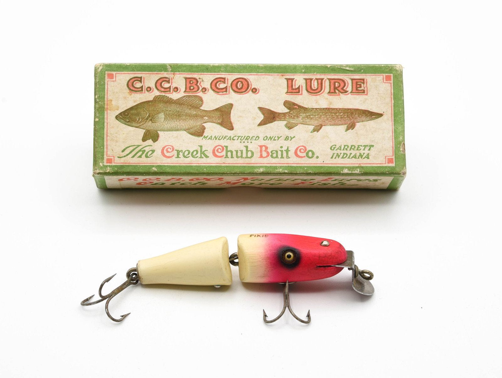 Creek Chub Baby Jointed Pikie Special: Finished in very rare uncataloged fluorescent pink head and cream body, with gold back stamp, VG+/Ex- due to age lines, a few tiny pointers, light soiling and one hairline. Coming in its correct SPECI