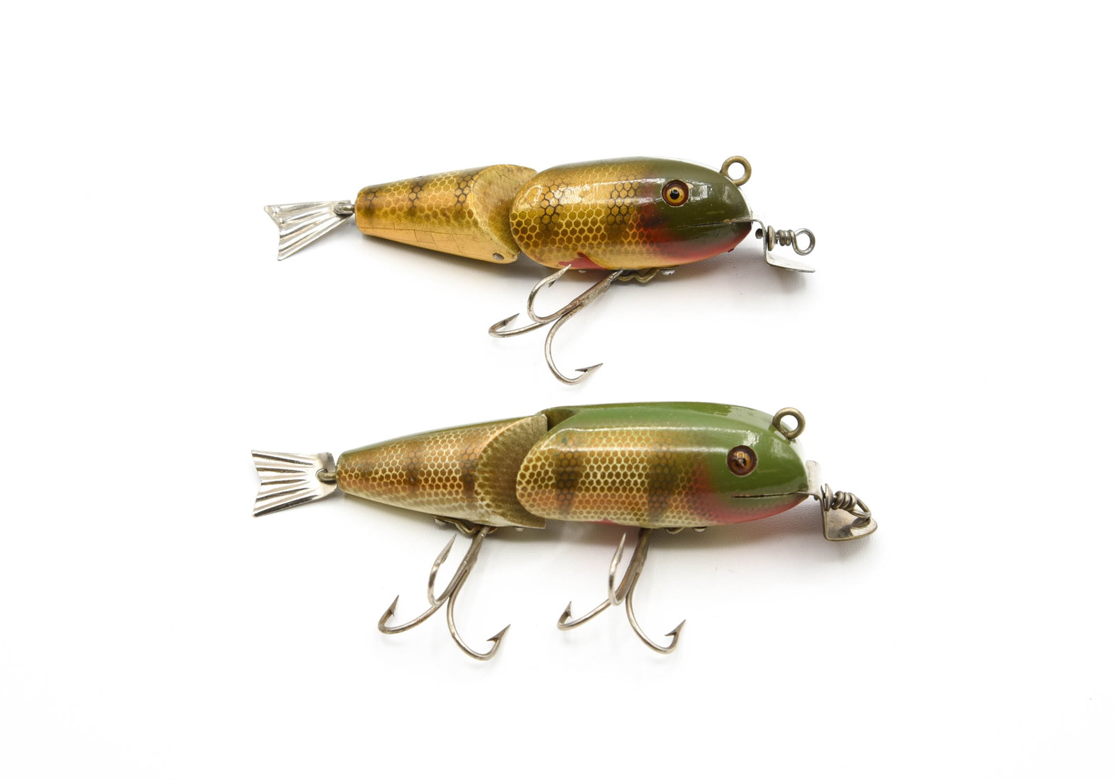 DAM 3119 Bass-Wobblers: Both rigged with glass eyes and finished in perch scale with hand painted fins. Measuring 3" and 3 3/8", each with the interlocking V-shaped joint, L-rig style hardware, fluted tail and red painted ch
