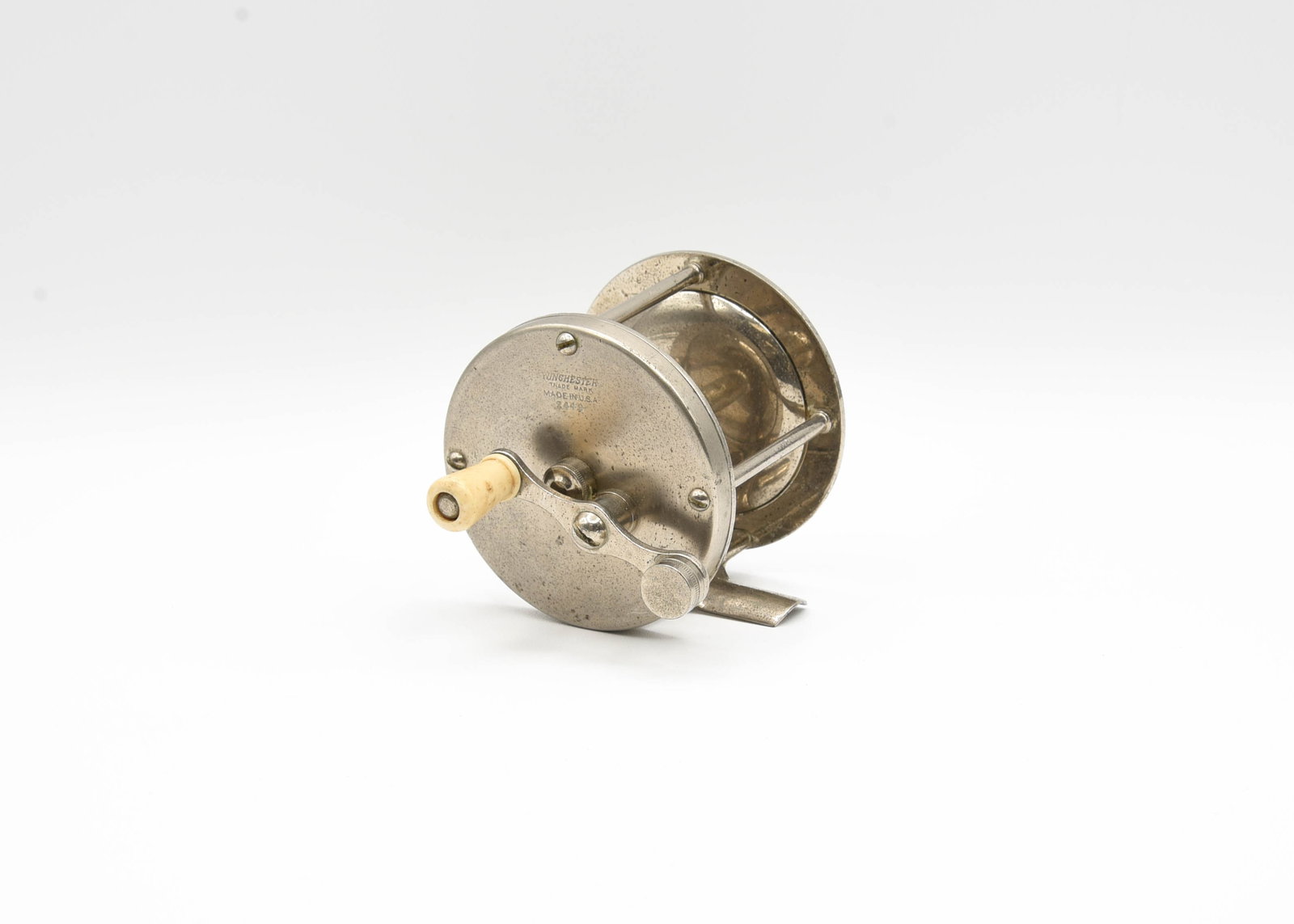 Winchester 2449 Casting Reel: Marked "Winchester Trademark Made in U.S.A. 2449", 100yd size (stamped foot), plain end caps, working click and drag switches and a counter balanced handle. Ex- condition with light wear, soiling and 