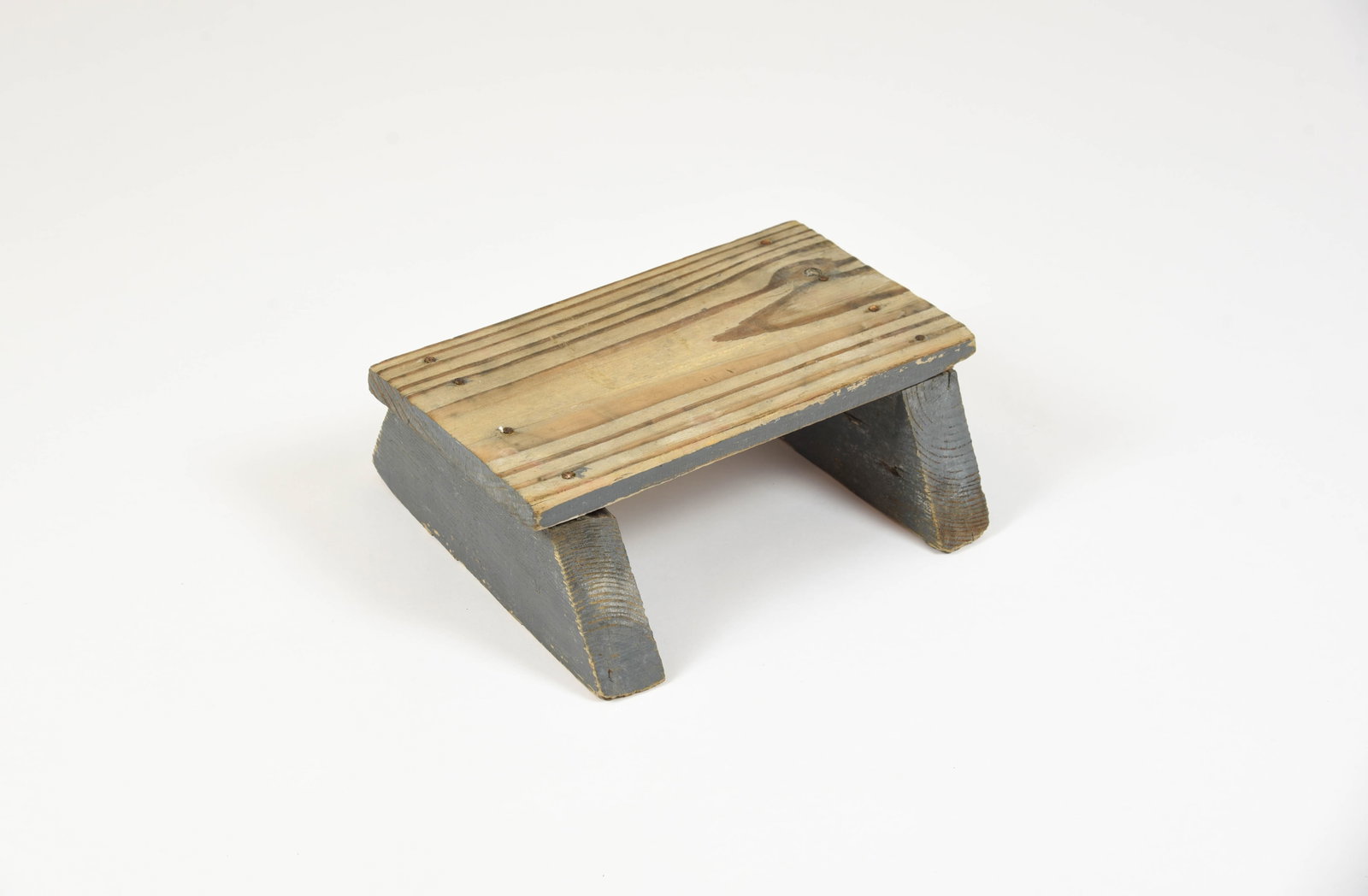 Creek Chub Factory Footstool: This simple wooden footrest was used for many years by Creek Chub lure painter Martha Custer, originating from the Garrett, Indiana factory. The top board measures 12" x 6 1/2", the sides are painted 