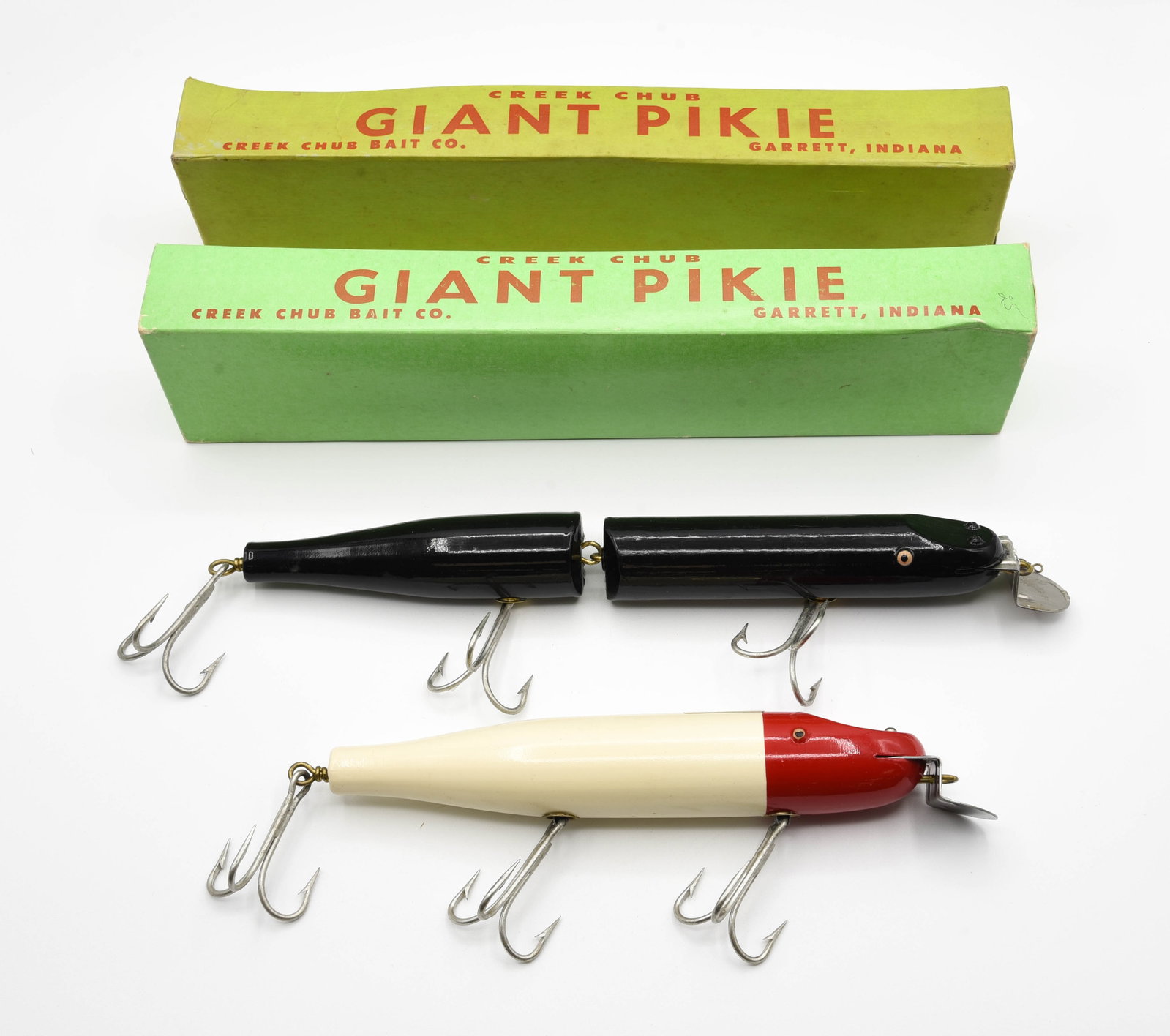 2 Creek Chub Giant Pikies: Tack eye models including a 6000 in red head white with a back decal, unfished Ex with only light box wear, in the correct 6002 Wood stamped box. And a Giant Jointed Pikie in solid black, most likely 