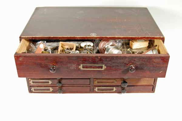 9 Drawer Jewelers Cabinet: filled with watch making and clock tools. Label on Cabinet - KK System genuine guarantee. 18 1/2" wide x 9" tall x 11" deep. Provenance: from an estate in Middlebury, VT along with a collection of clo