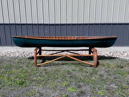 Small Paper-Hulled Canoe: Green exterior with finished bent ribs (only at center) and three thwarts. No seats. Paddler would kneel or sit on the bottom of the canoe. This boat is being sold for the Adirondack Experience in Blu