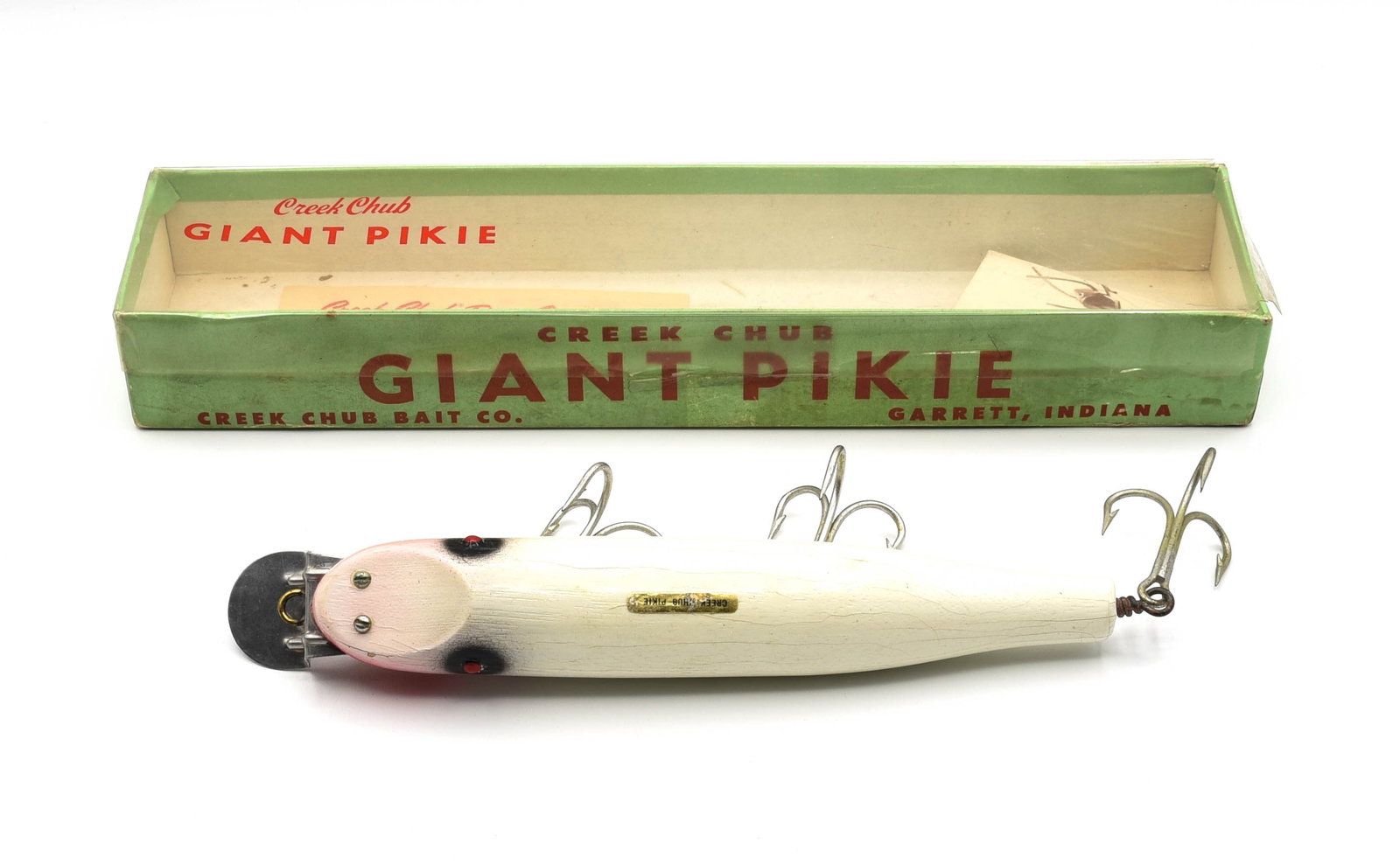 Creek Chub Giant Pikie: Finished in rarely seen white with black eye shadow and red chin blush, a short production color on the tack eye Giant. Coming in a faintly stamped 6012 WOOD box, correct for this 70s bait produced du