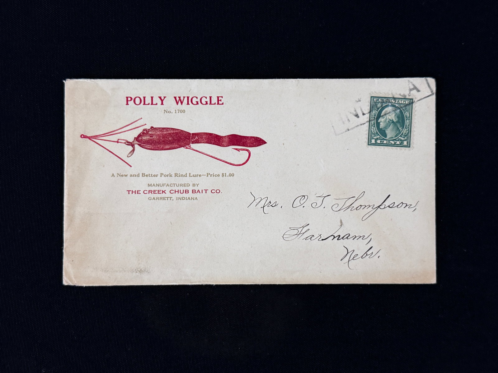 1922 Creek Chub Illustrated Envelope: Very rare envelope printed in red and green for the 1922 announcement of the Polly Wiggle. The envelope measures 6 1/2" in length with a bold and crisp illustration of the lure in color, including the