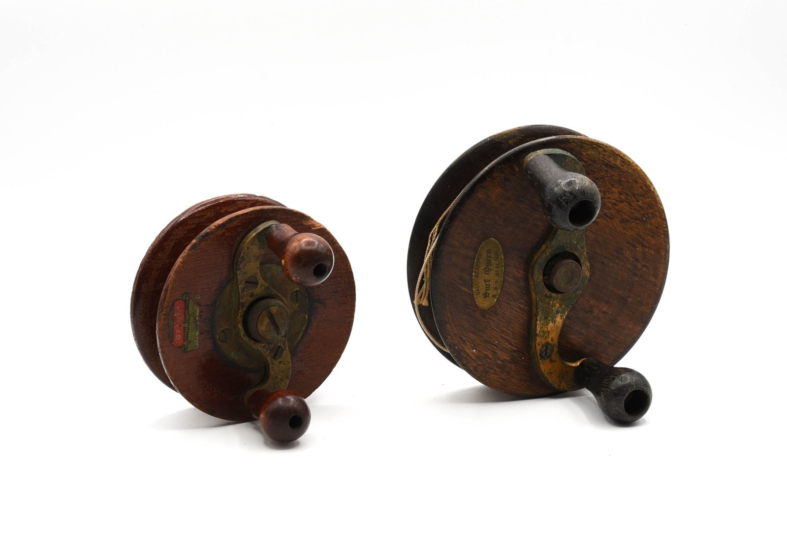 2 Nottingham Trolling Reels: Wood reels measuring 4" and 5" diameters, marked Cozzone and Surf Queen B&B Reel Co. Each with a dual grasp handle, brass foot and in VG/VG+ condition.