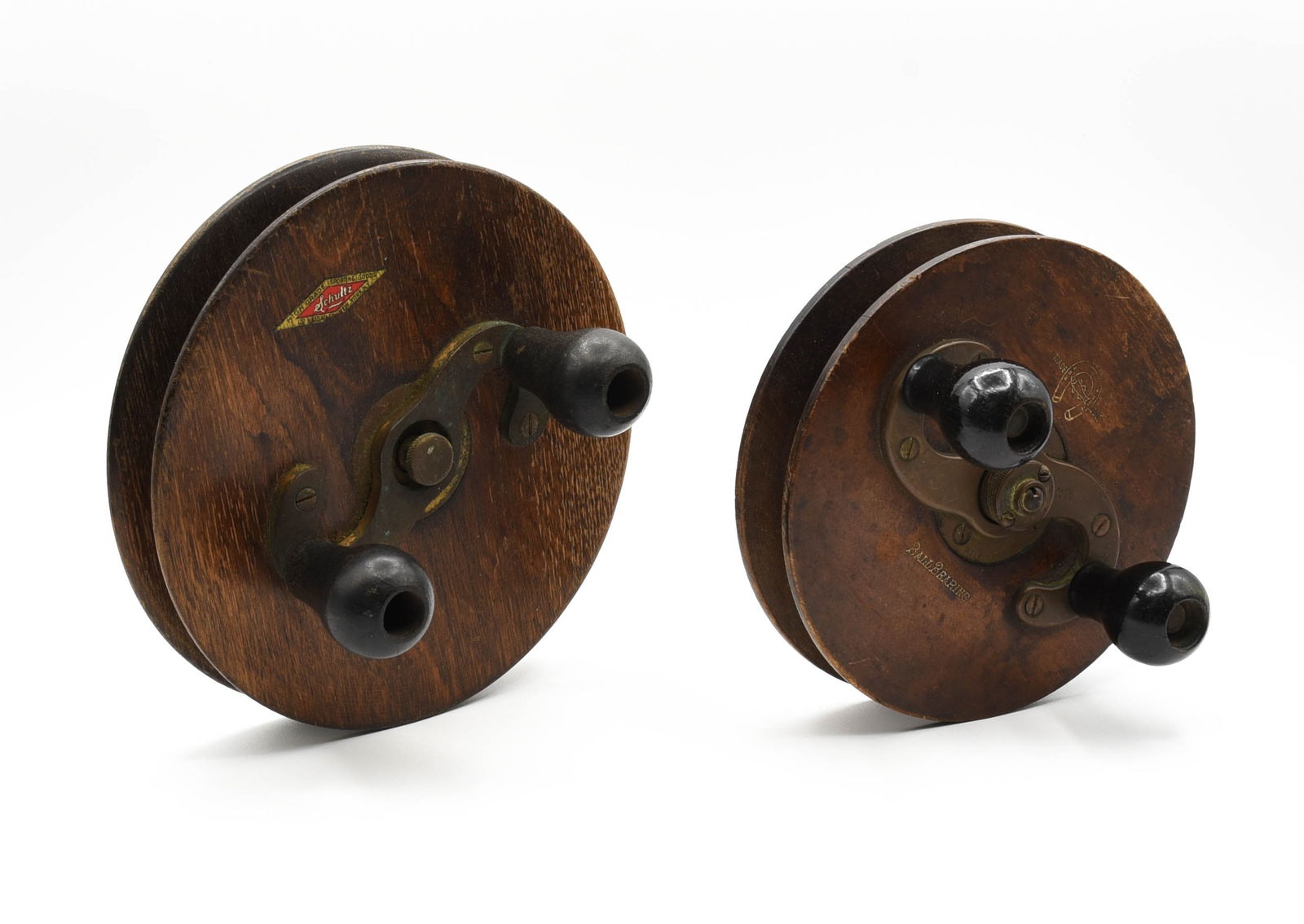 2 Nottingham Trolling Reels: One marked with the horseshoe & fish logo, 6" diameter, VG/VG+ condition, and the other marked "High Grade Sporting Goods 122 Nassau St. New York, N.Y." with Schultz in the center, 7" diameter, about