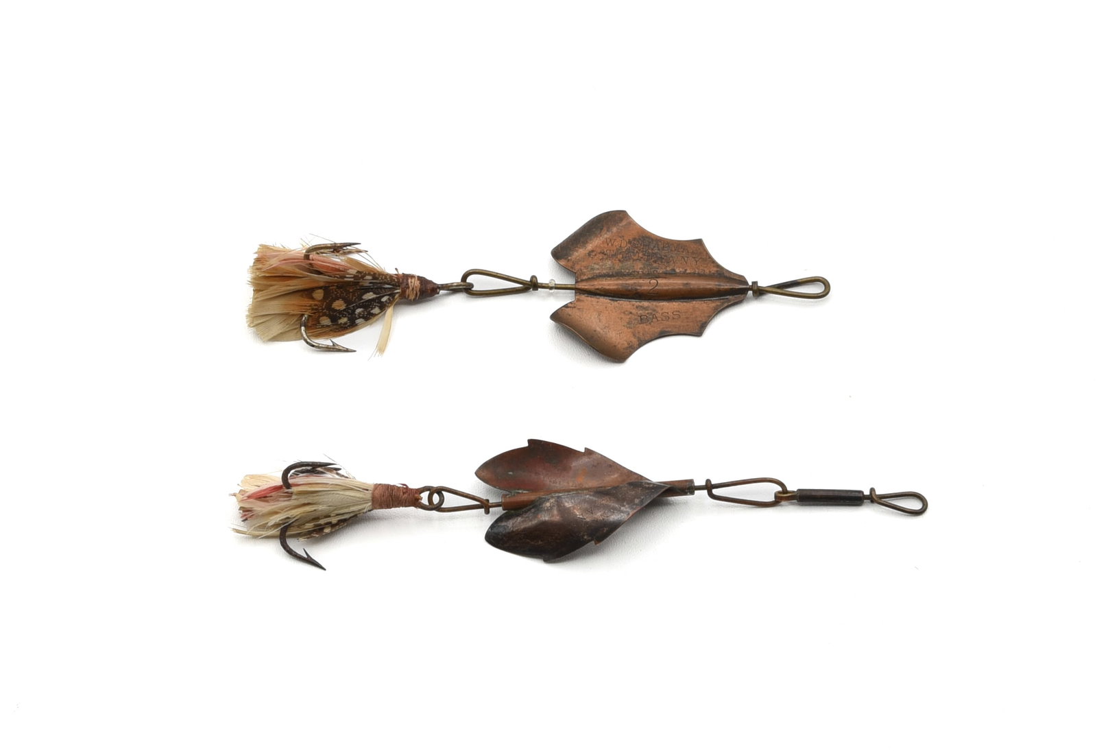 Chapman No. 2 Bass Bait & Allure: 1 5/8" blade is stamped "W.D. Chapman Theresa, N.Y." and "Bass" on the opposing wing. Retaining its clear bead spacer and feathered treble hook, in Ex- condition with age darkened patina. And a size