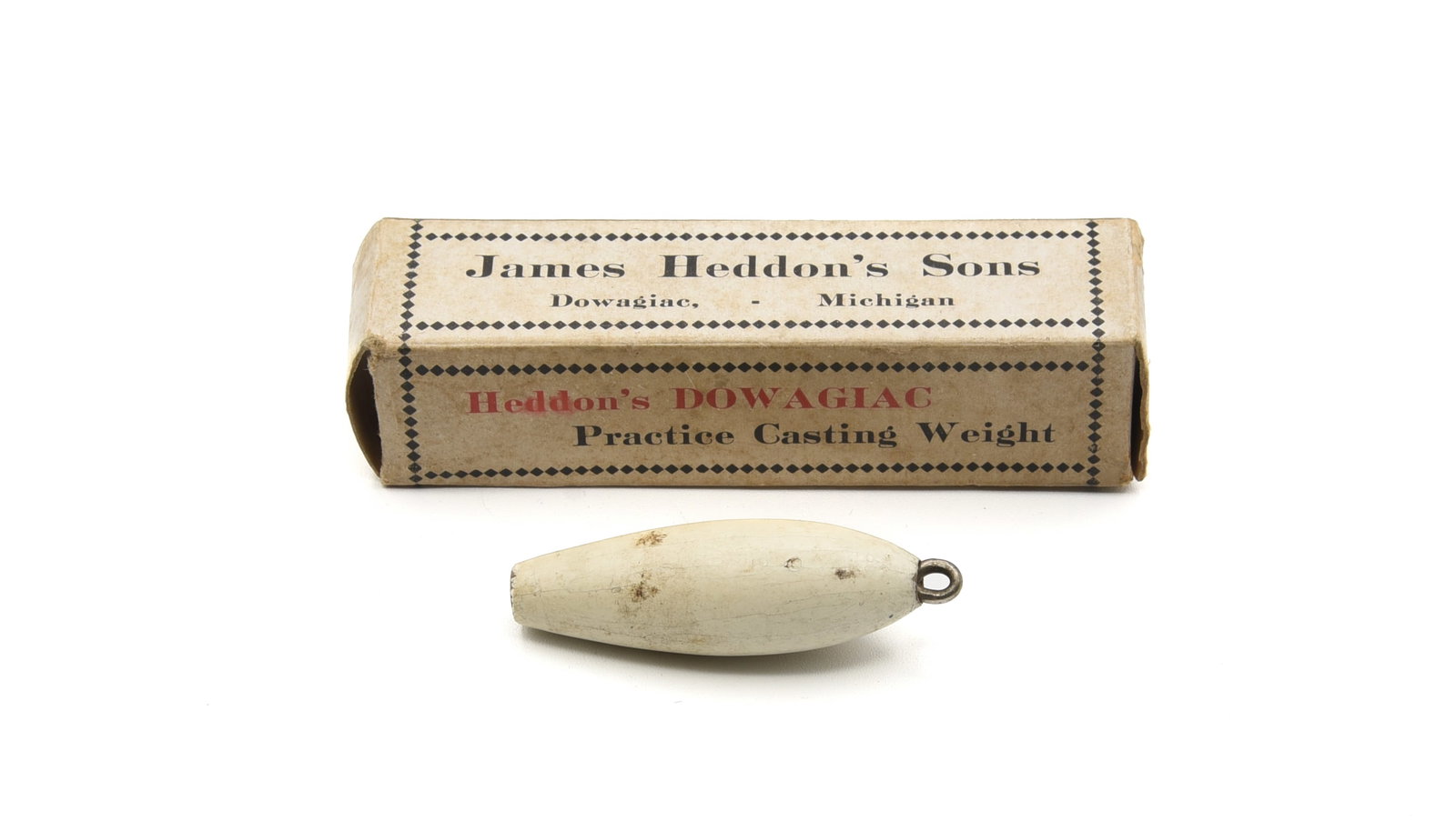 Heddon Tournament Casting Weight: Coming in its very rare one-piece "Heddon's Dowagiac Practice Casting Weight" box is this 2 1/4" tournament weight. All white painted finish with recessed line tie and blunt lead base, about VG+ due t
