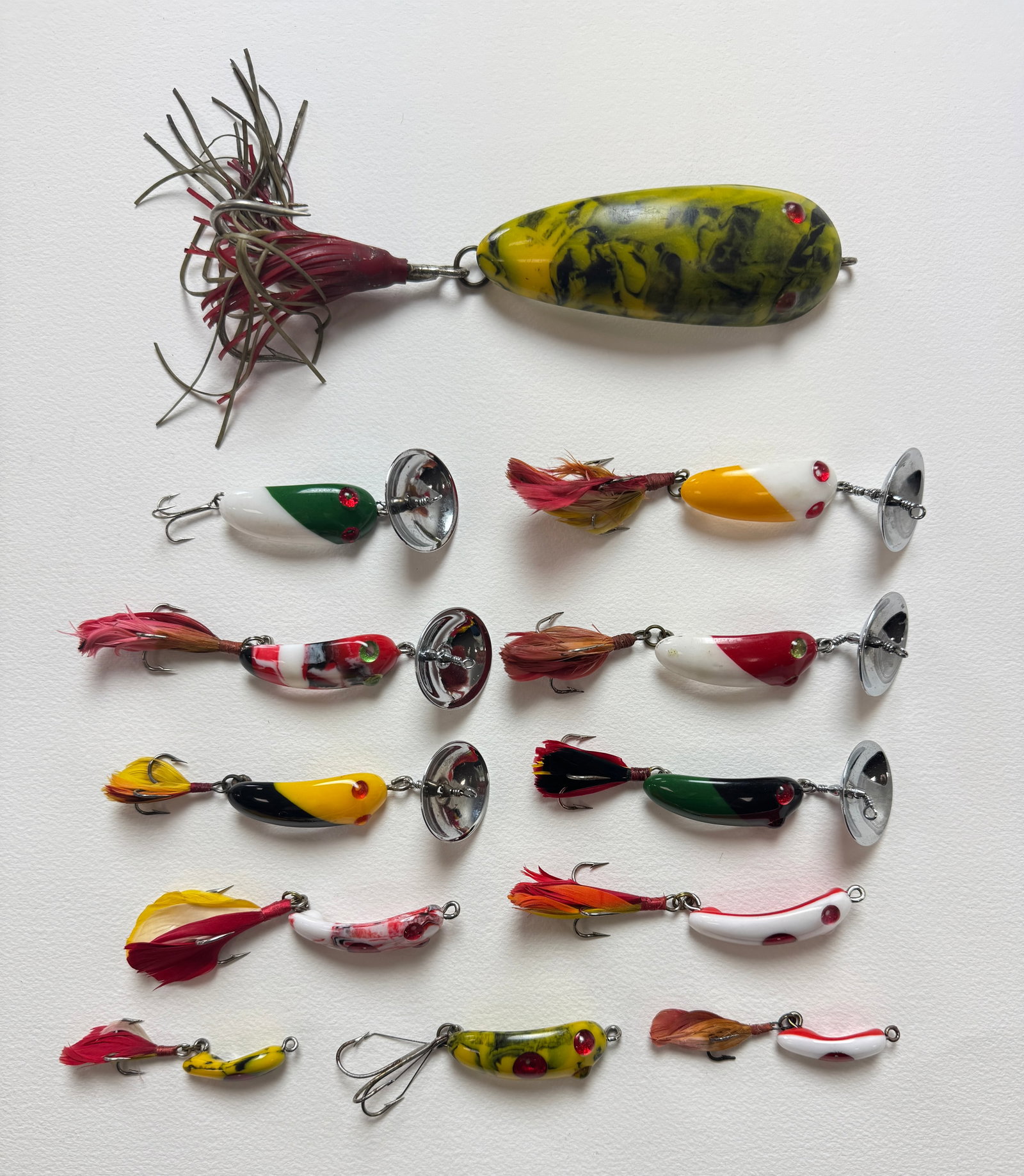 12 Vintage Canadian Baits: A nice group of colorful lures, several models in multiple sizes, including a musky with its body measuring nearly 4 1/2" in length. The cupped spinners are stamped Pat. Pend. and Made in Canada.