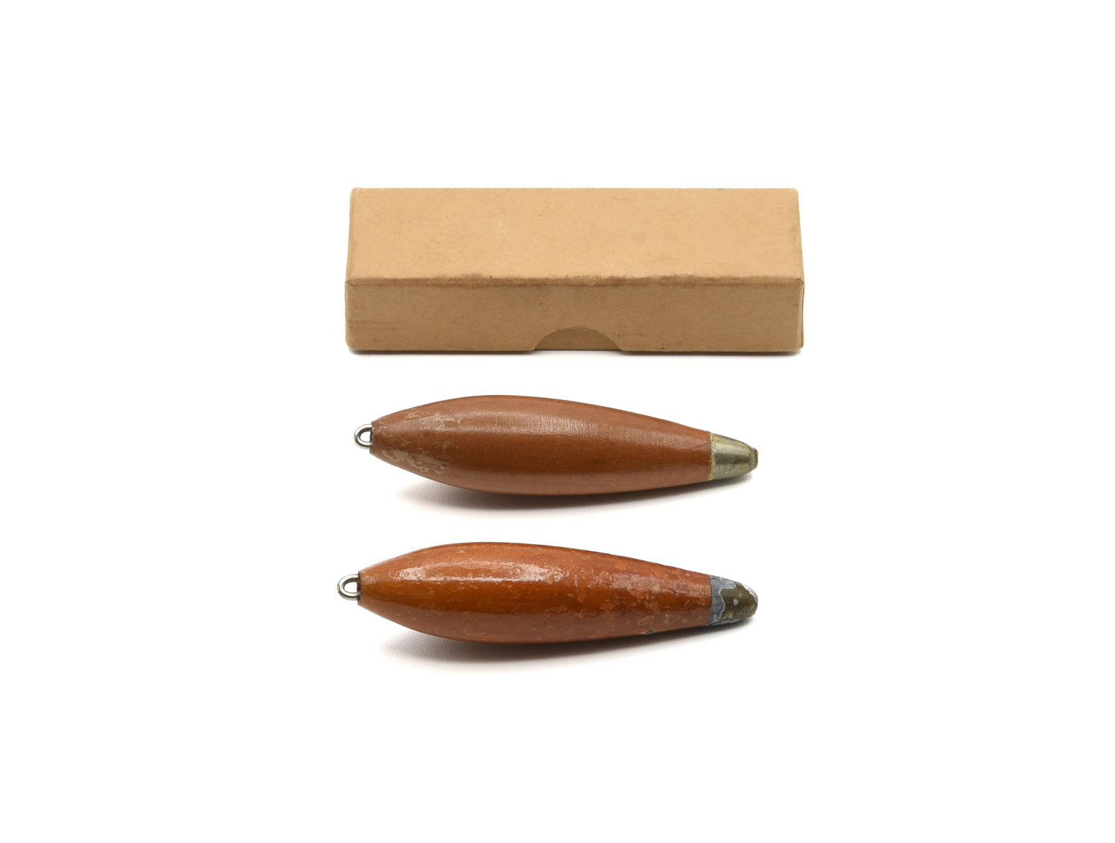 Heddon Wooden Casting Weights: Two rare unmarked Heddon weights in natural wood finish, both measuring 3 1/4" overall with a heavy lead base, recessed line tie and tapered body, Ex- and VG+. Also included is a 3 7/8" two-piece box,