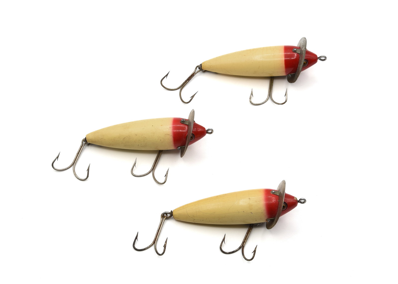 3 Heddon 210 Surface Baits: All rigged with removable double hooks, good glass eyes, 2pc hardware and finished in red/white. Condition from VG+ to Ex-.