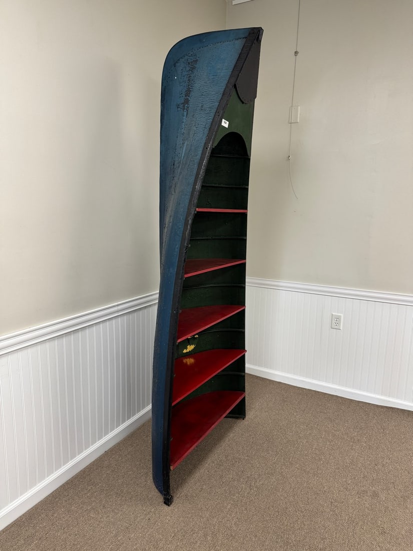 Adirondack Guideboat Display Shelf: 88" tall, 35" wide, exterior in original blue paint, red painted shelves are removable. Made from an original guideboat used at Whitney Park. From Camp Deerlands.