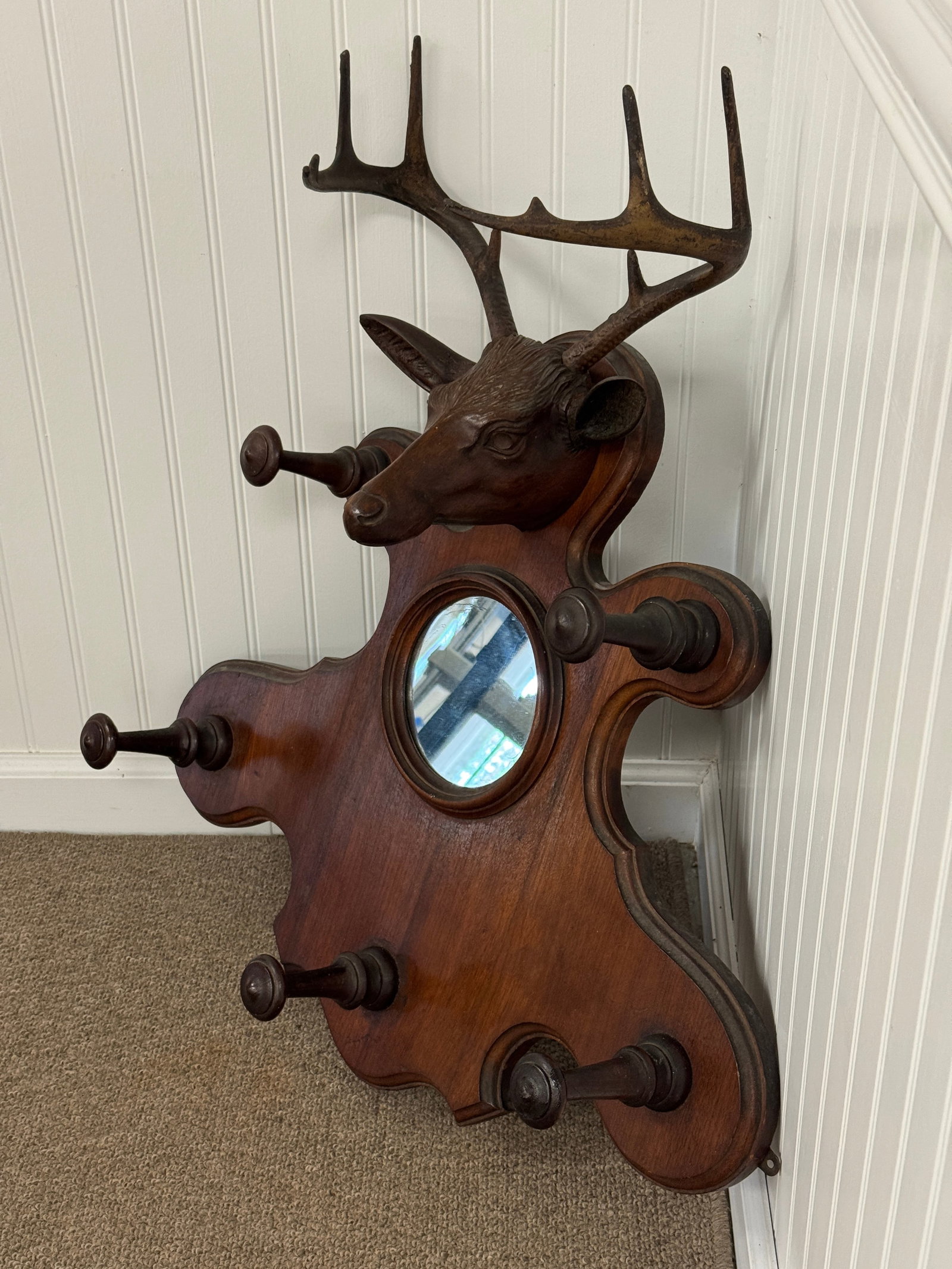 Black Forest Hat Rack with Mirror: Finely carved deer head with cast metal horns. 6" round mirror and 5 wooden turned hat hooks. 26.5" wide x 30" tall.