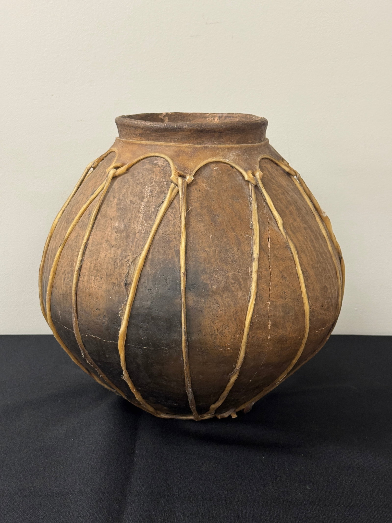 Southwestern Pottery Vessel w/ Rawhide: has a crack, 11.5" tall.