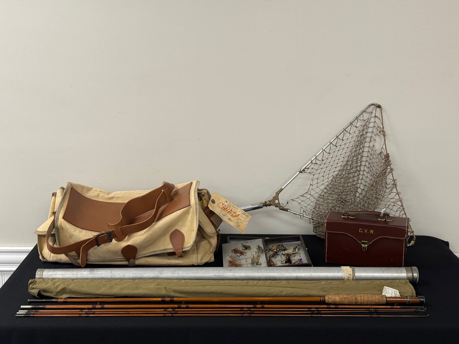 C.V. Whitney's Fly Fishing Gear: includes a leather initialed fly box complete with salmon flies, canvas creel, E.F. Payne 9' 3/3 bamboo fly rod and net.