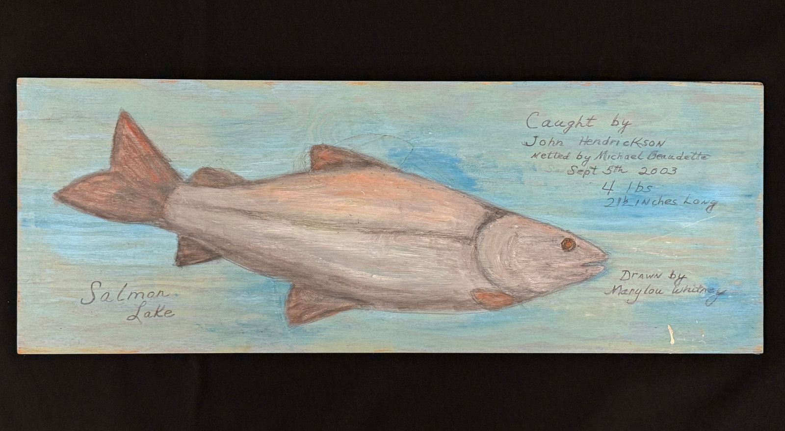 Marylou Whitney Lake Trout Fish Painting: Caughy by John. Hendrickson, 2003. Board measures 28" x 10.25". Painted by Marylou Whitney. Folk art painting on wooden board from Trappers Cabin at Salmon Lake in Whitney Park.