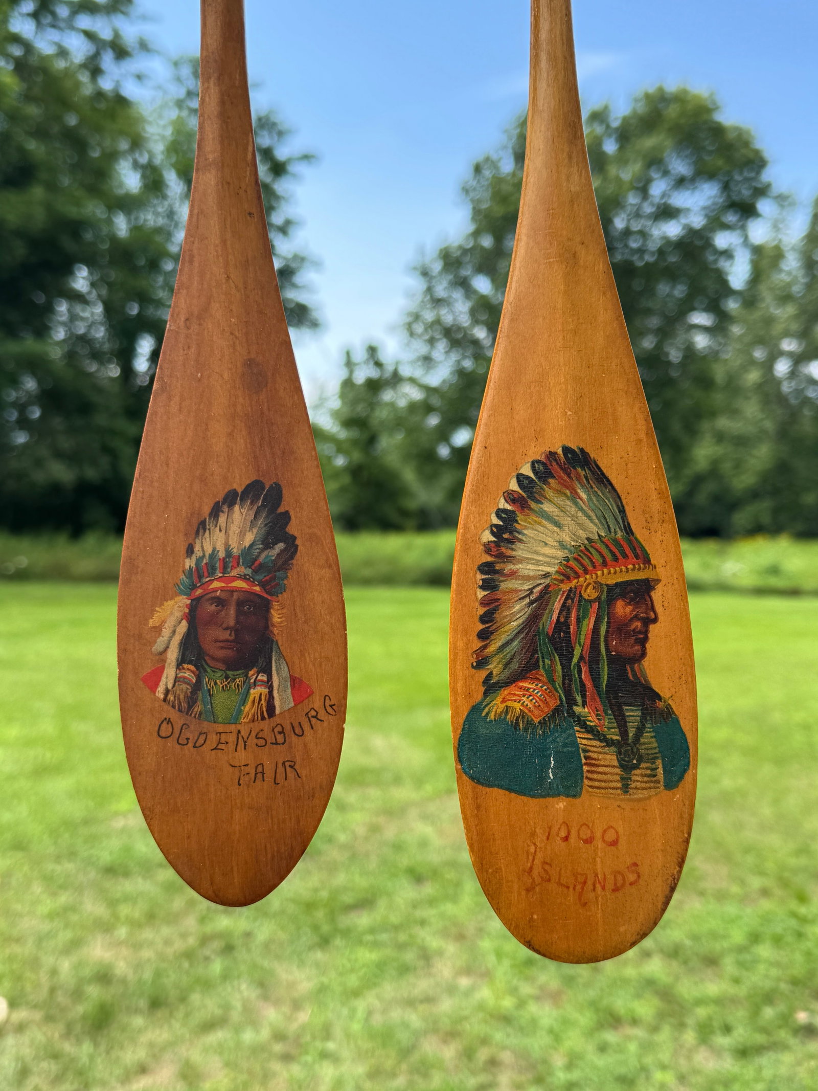 2 Thousand Islands Souvenir Paddles: in the style of Keech. Both with Indians. 18" and 22" long. From the Estate of Dr. Dean Hyde, Clayton, NY.