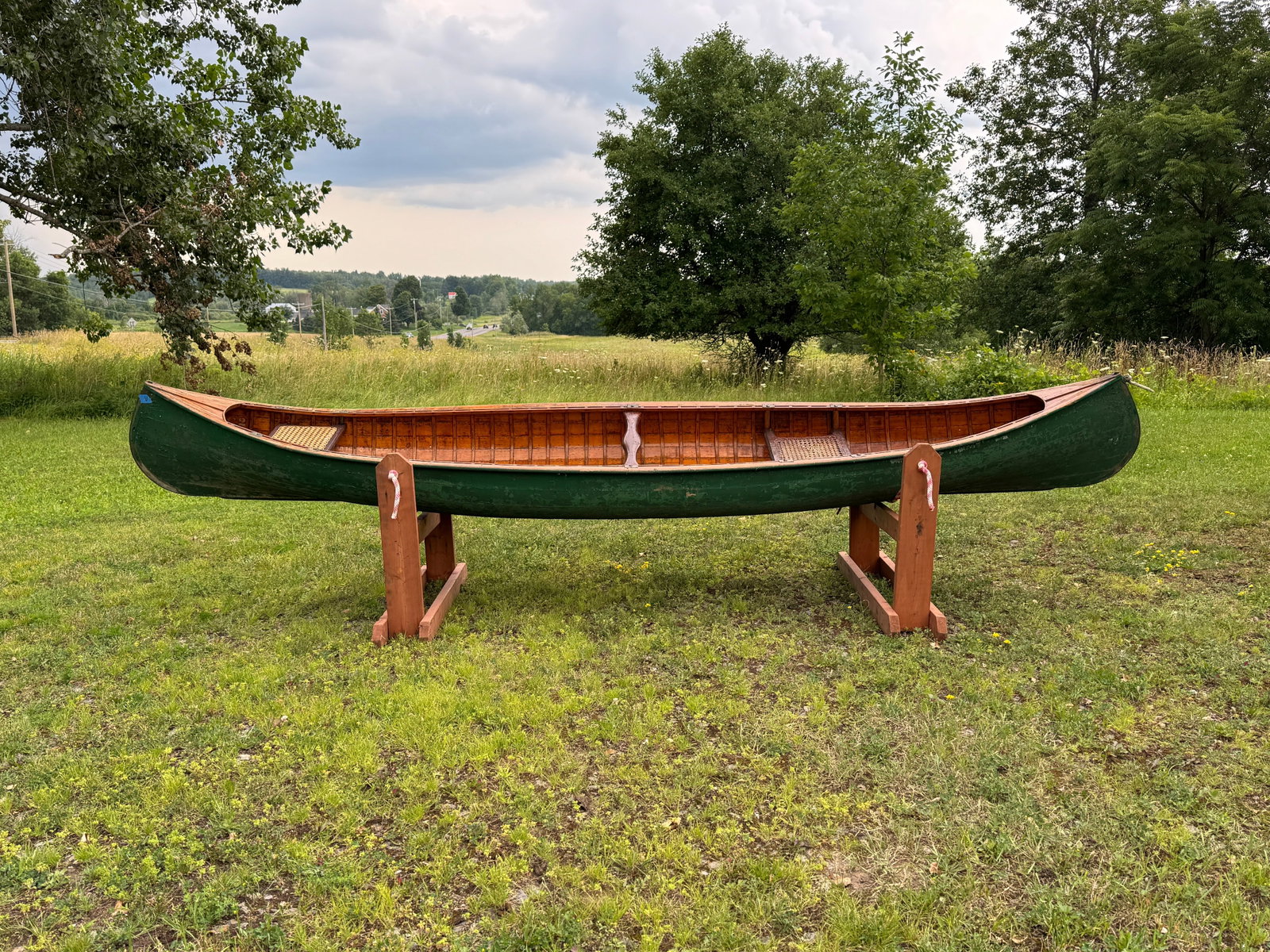 A.B. Moody Smooth Skin Open Paddling Canoe: Circa 1920s. Exterior painted green with natural interior. 32" wide. Caned seats. Stenciled C2 from Whitney Park, Adirondacks.