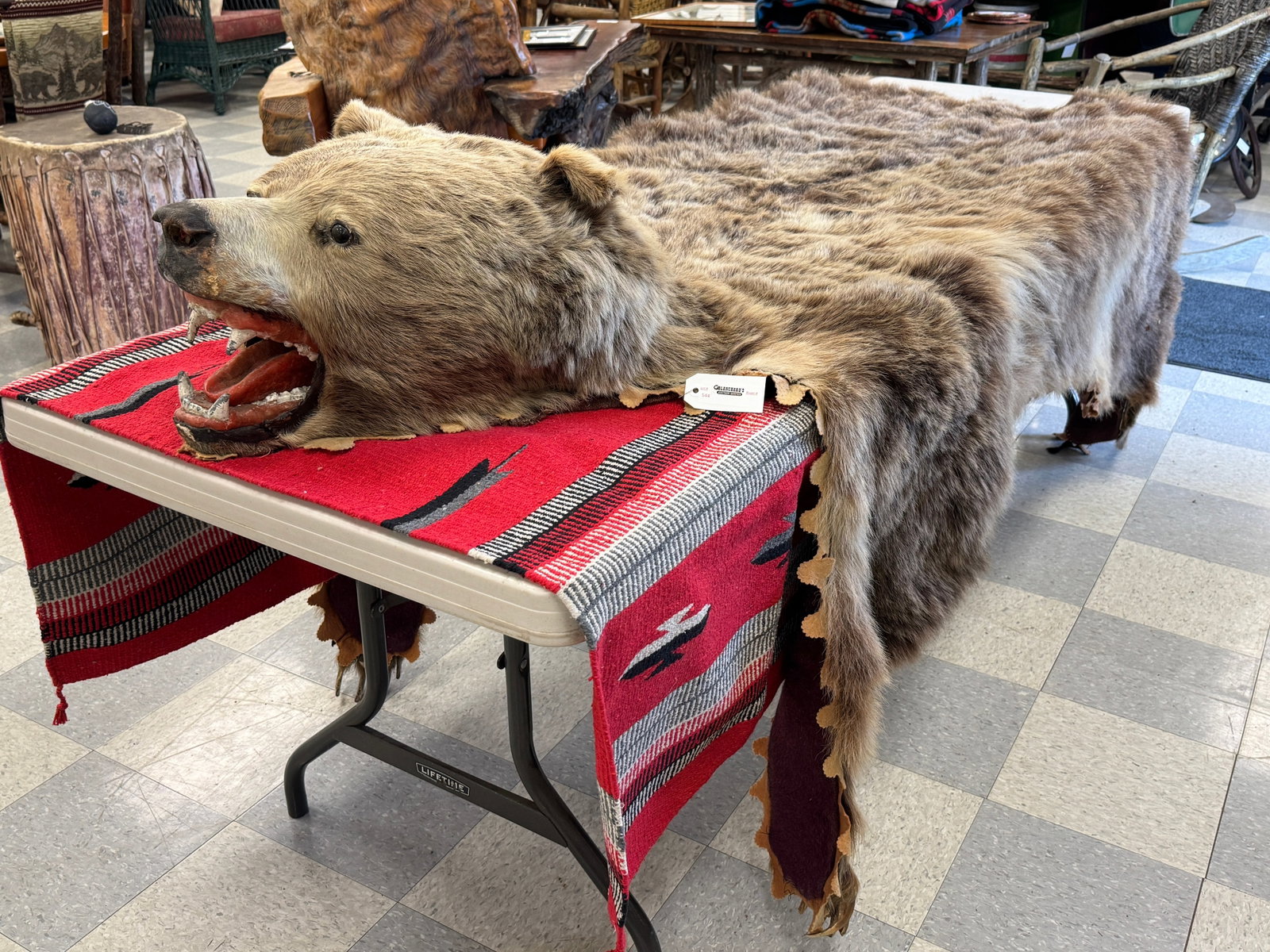 Early Grizzly Bear Rug: bear has a massive head , good to fair condition, with felt back liner, early 1900s. Some wear, sun fading, missing all 10 back claws and one front claw. From Camp Deerlands, Whitney Park.