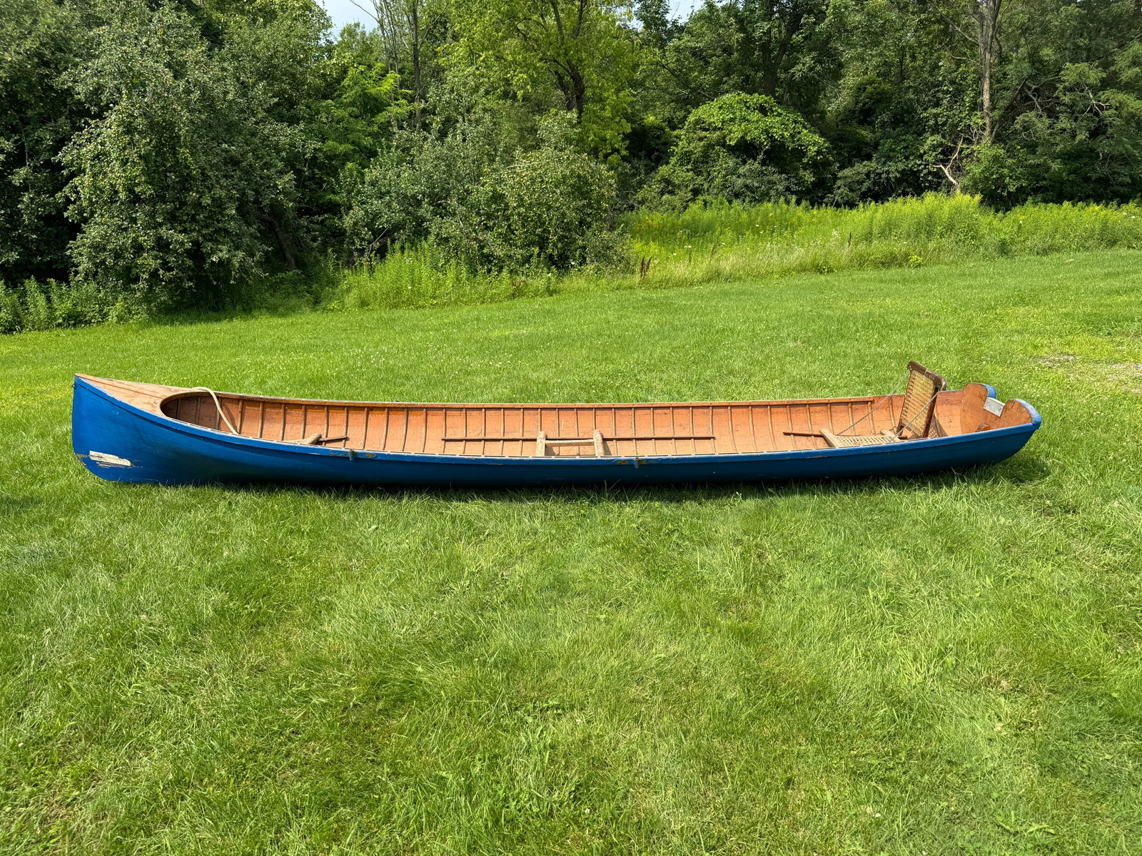 Adirondack Guide / Freight Boat - 16' long: square stern, blue painted exterior, interior is natural, solid boat that appears to be sea worthy, seats need re-caning. From Whitney Park, Adirondacks.