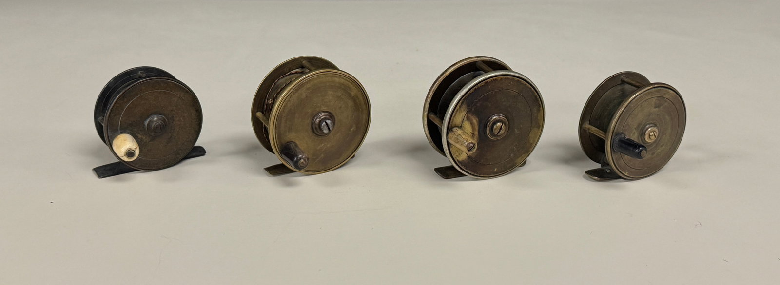 4 Early Brass Fishing Reels: largest is 2 3/4 inch diameter.