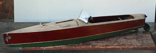 1930's Vintage Kellner German Toy Speed Boat: powered by a key wind clock work, 32" long, faux mahogany sides, green painted bottom, white painted deck.