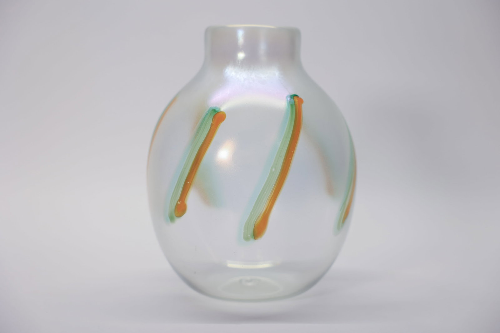 Iridescent Art Glass Vase, Trailed Design: A striking piece of vintage art glass, its clear, softly iridescent body accented with trailed ribbons of green and orange glass pulled vertically around the form. The applied trailed decoration is a 