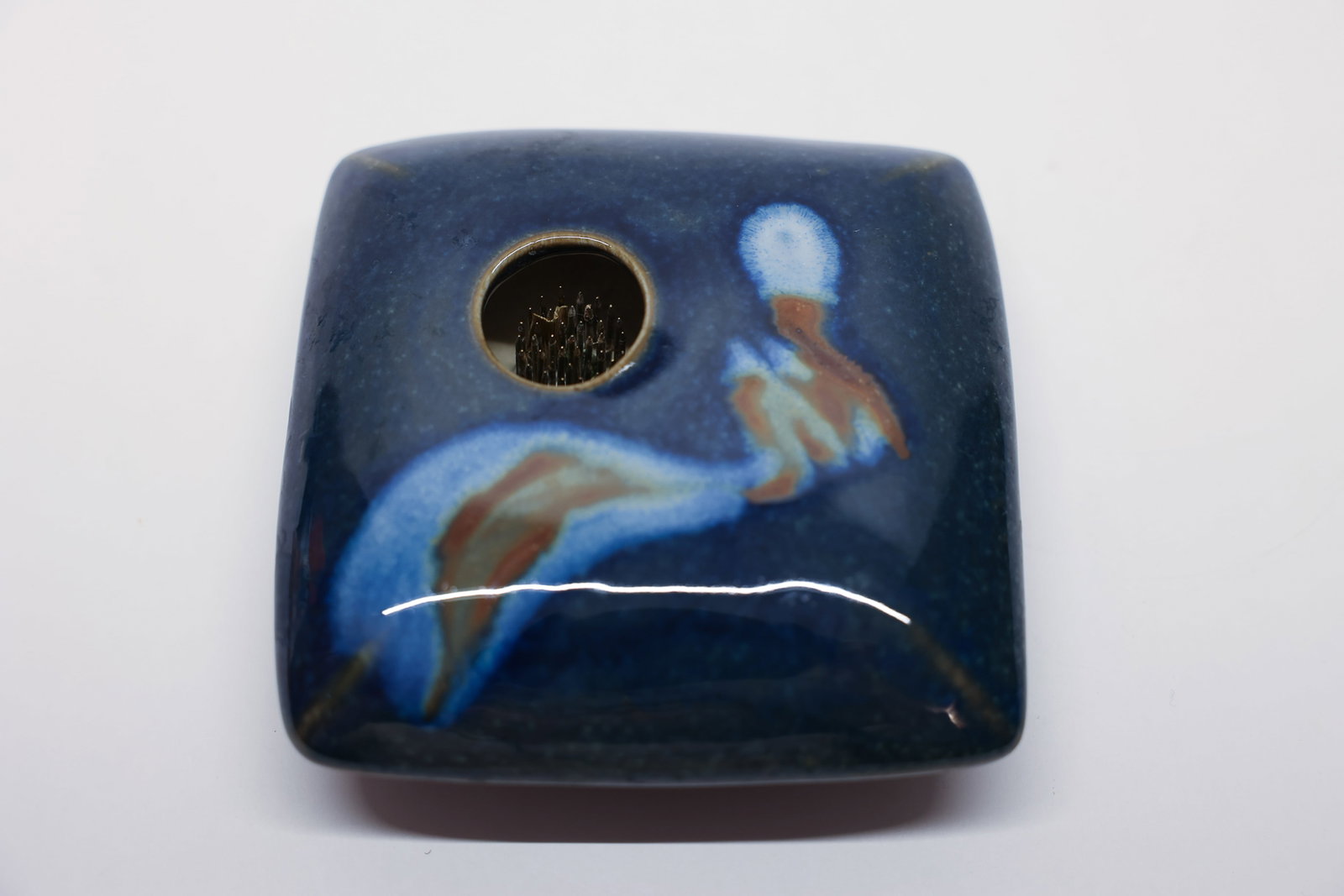 Japanese Studio Pottery Ikebana Vase w Frog Signed: Elegant Japanese studio pottery ikebana vessel featuring a square, gently rounded form finished in a rich indigo-navy glaze. The top is hand-painted with a soft, brush-style botanical motif in dusty