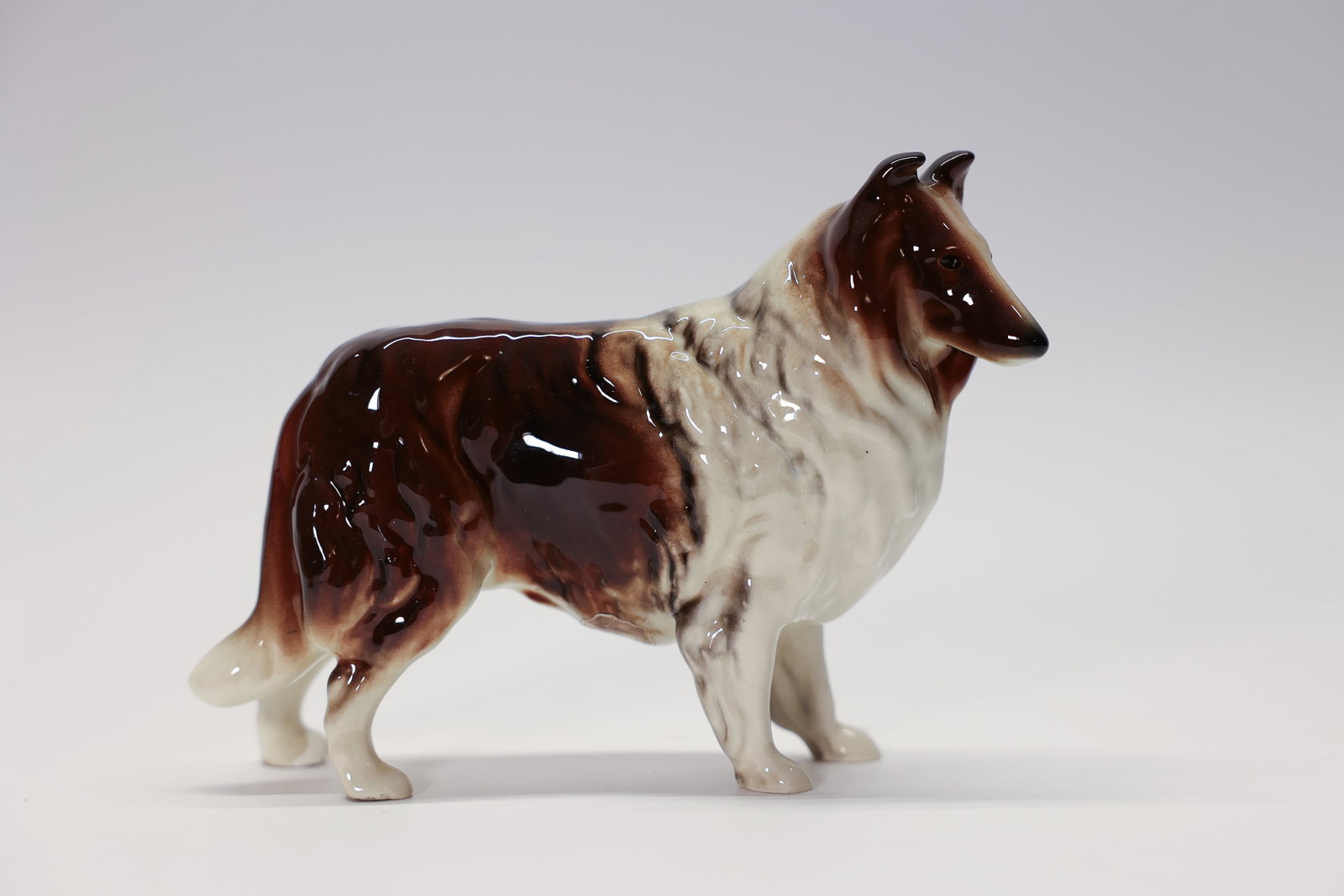 Robert Simmons Ceramics Collie Dog Figurine: Vintage porcelain Collie dog figurine by Robert Simmons Ceramics, Los Angeles, marked with the original "Handmade Art Wear" sticker. Beautifully hand-painted in a rich mahogany-brown and white sable p