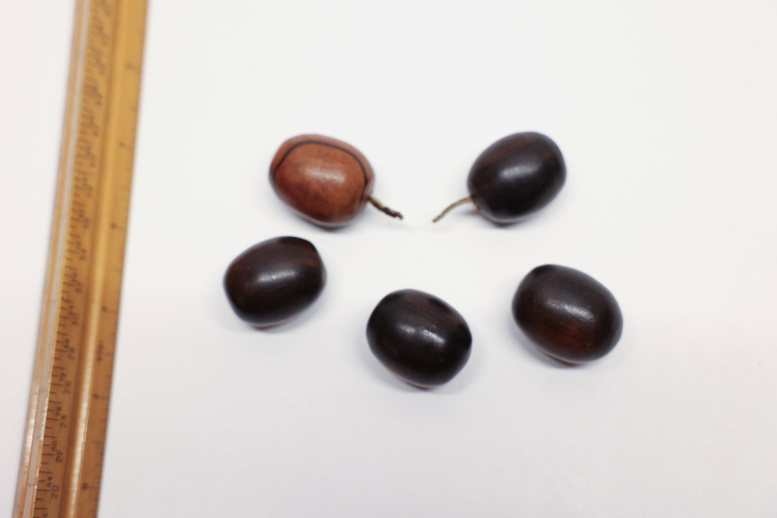 Mid-Century Rosewood Carved Grape Cluster: A lovely set of five hand-carved and polished wooden "grapes," crafted from rich rosewood or ironwood in the mid-century decorative style. Four grapes display a deep, glossy espresso-brown tone with s