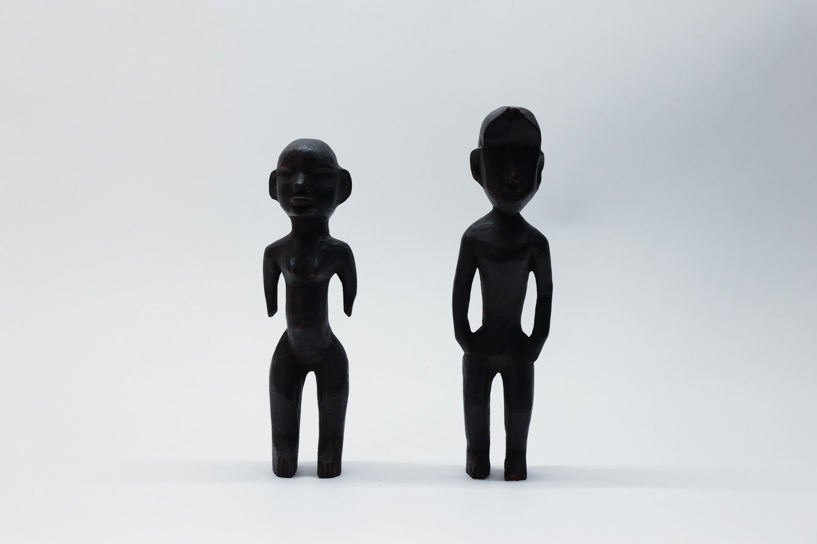 African Carved Wood Figures Pair Burkina Faso: Description:A striking pair of antique hand-carved wooden figures, possibly ancestor or fertility figures, likely originating from Burkina Faso, West Africa, dating from the late 19th to mid-20th