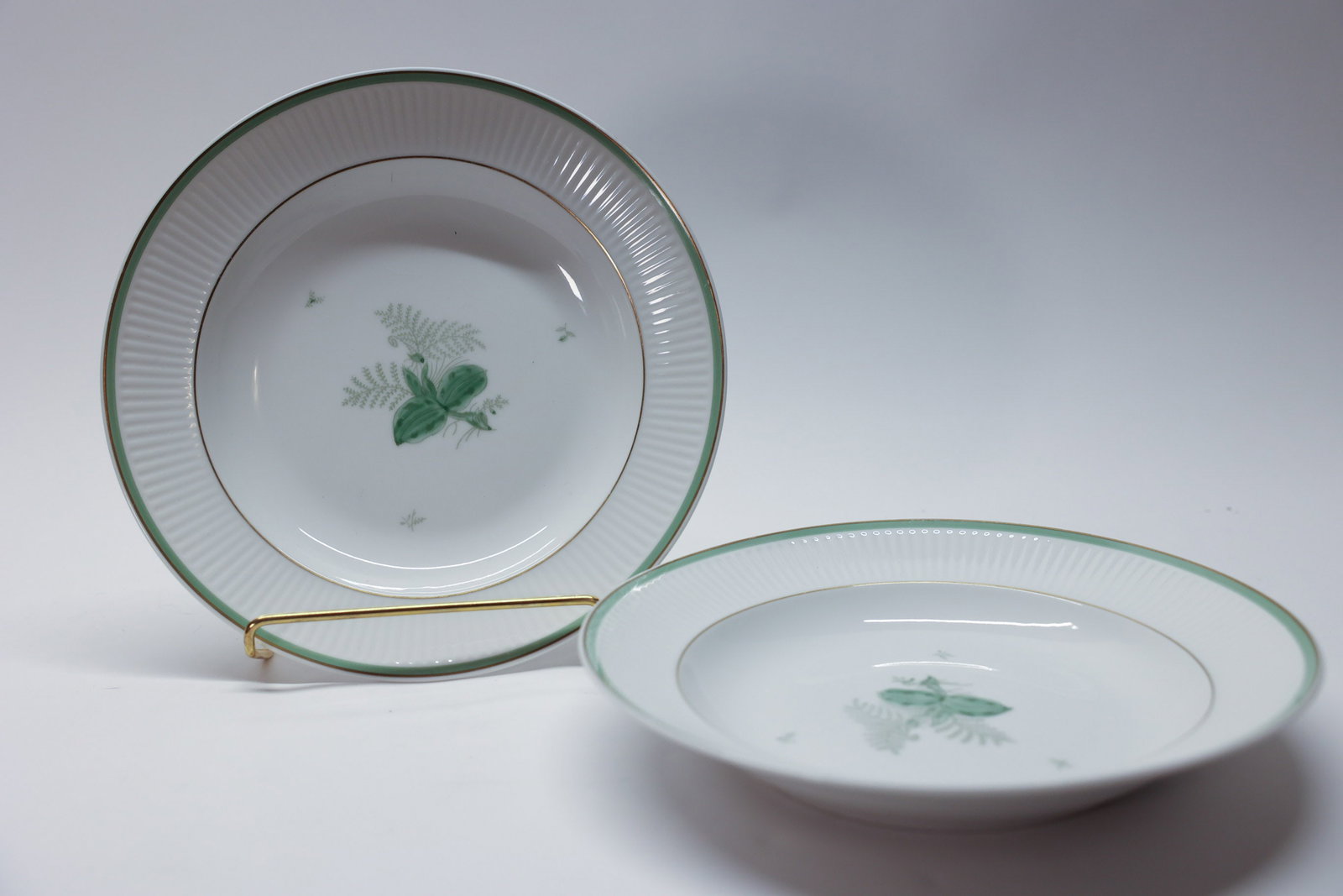 Royal Copenhagen Green Melody Plates: Vintage Royal Copenhagen handpainted porcelain plates in the discontinued "Green Melodi" (or "Green Melody") pattern, designed by Thorkild Olsen. Made in Denmark.Dimensions: H: 2", W: 9.75"