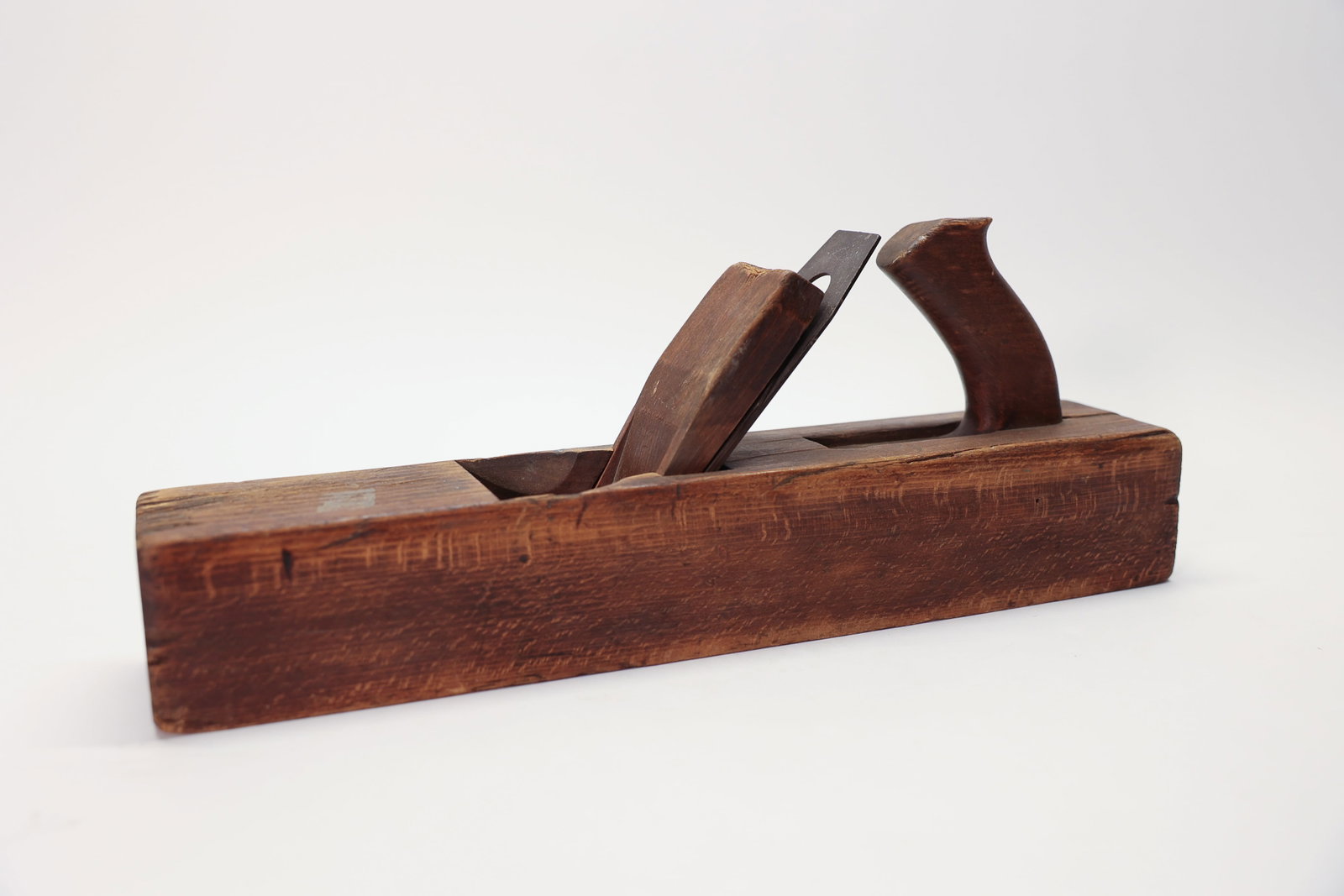 Antique Wooden Jointer Plane 15 7/8": A substantial antique wooden jointer/jack plane, measuring 15 7/8 inches long by 2 7/8 inches wide, crafted from solid hardwood with a rich aged patina throughout. The plane features a carved